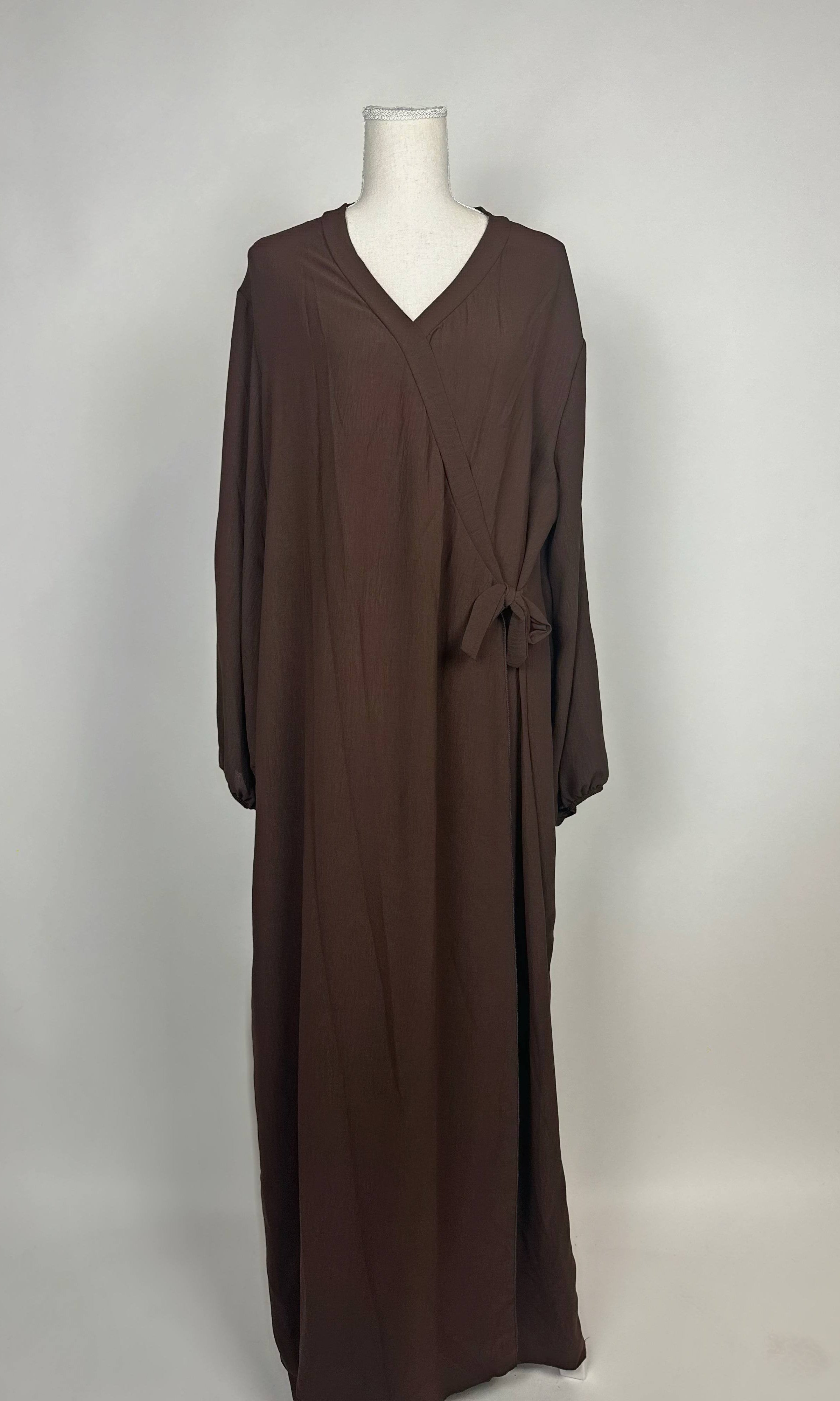 Braune Wickelabaya aus leichtem Stoff zeigt Ballonärmel und seitliche Schleife im Modest Hijab-Stil, Vorderansicht.