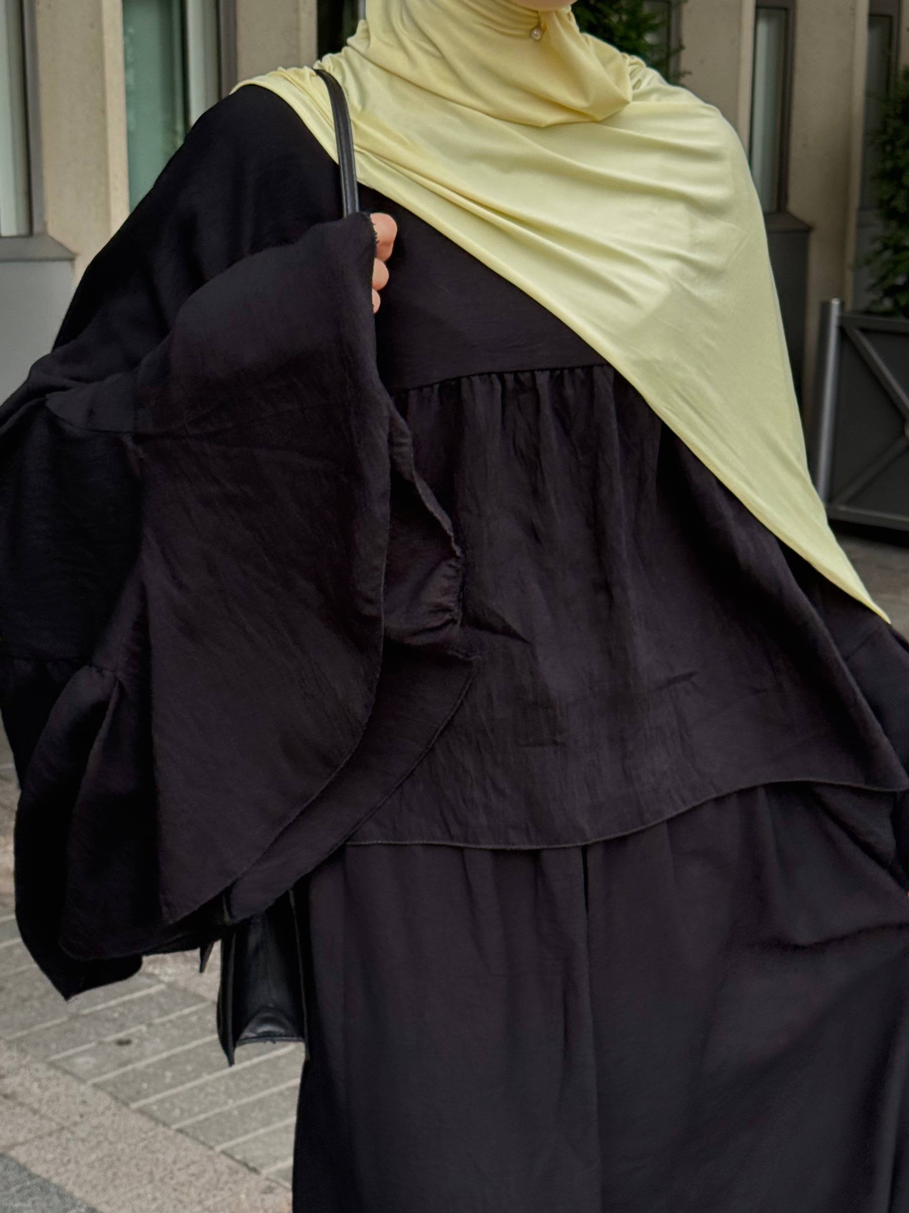 zweiteiler in schwarz mit lockerem oberteil, weiten volantärmeln und langem rock, strukturierter stoff, frontdetail