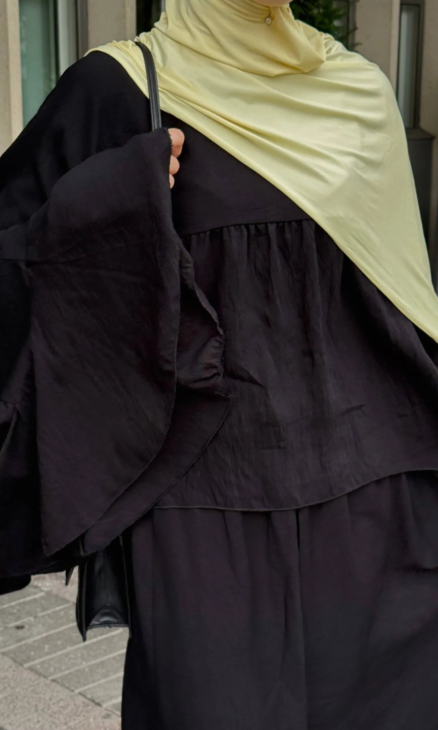 zweiteiler in schwarz mit lockerem oberteil, weiten volantärmeln und langem rock, strukturierter stoff, frontdetail