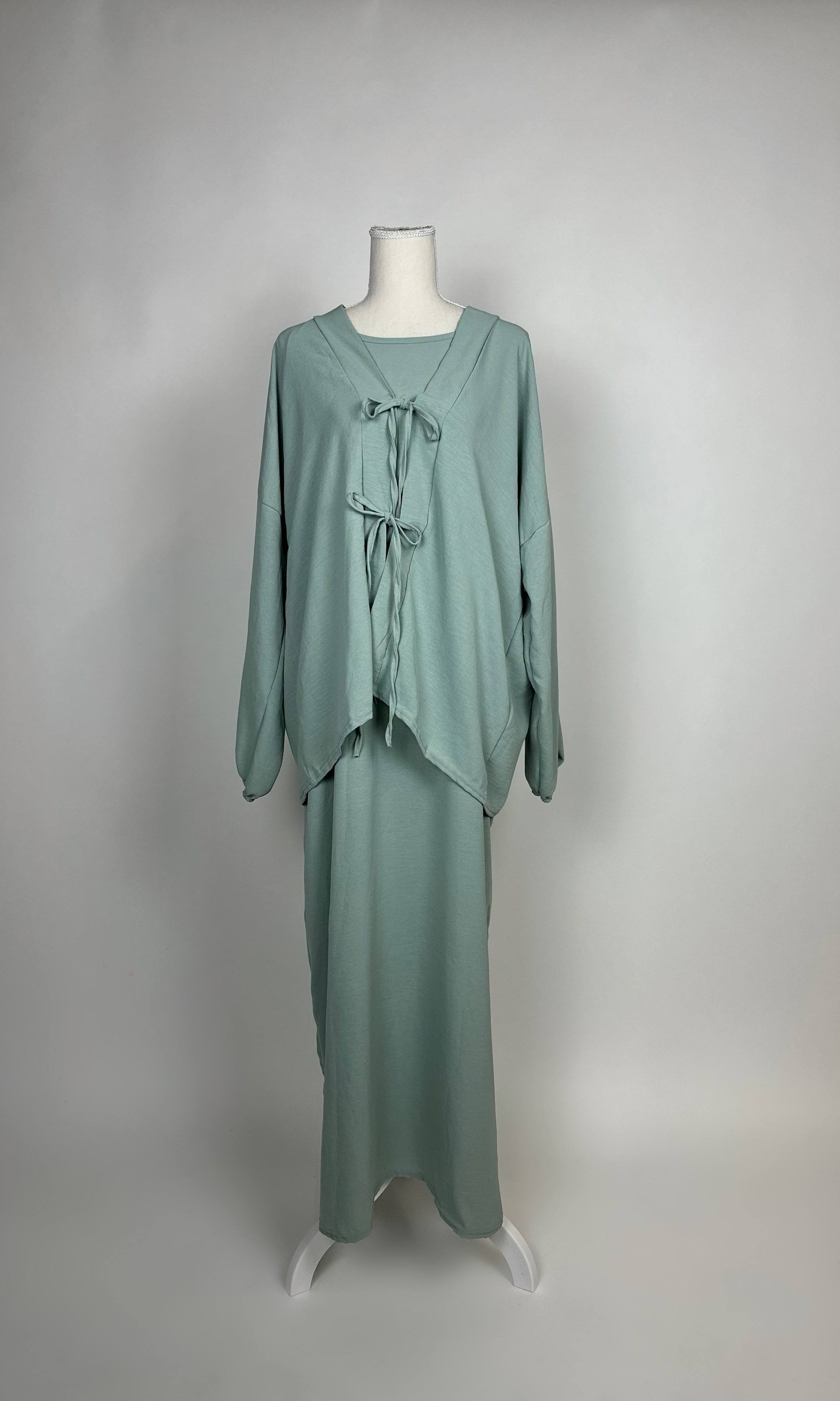 Salbeigrünes Abaya-Zweiteiler-Set aus Jersey im Modest-Stil mit Schleifen am Oberteil und Unterkleid, Vorderansicht.