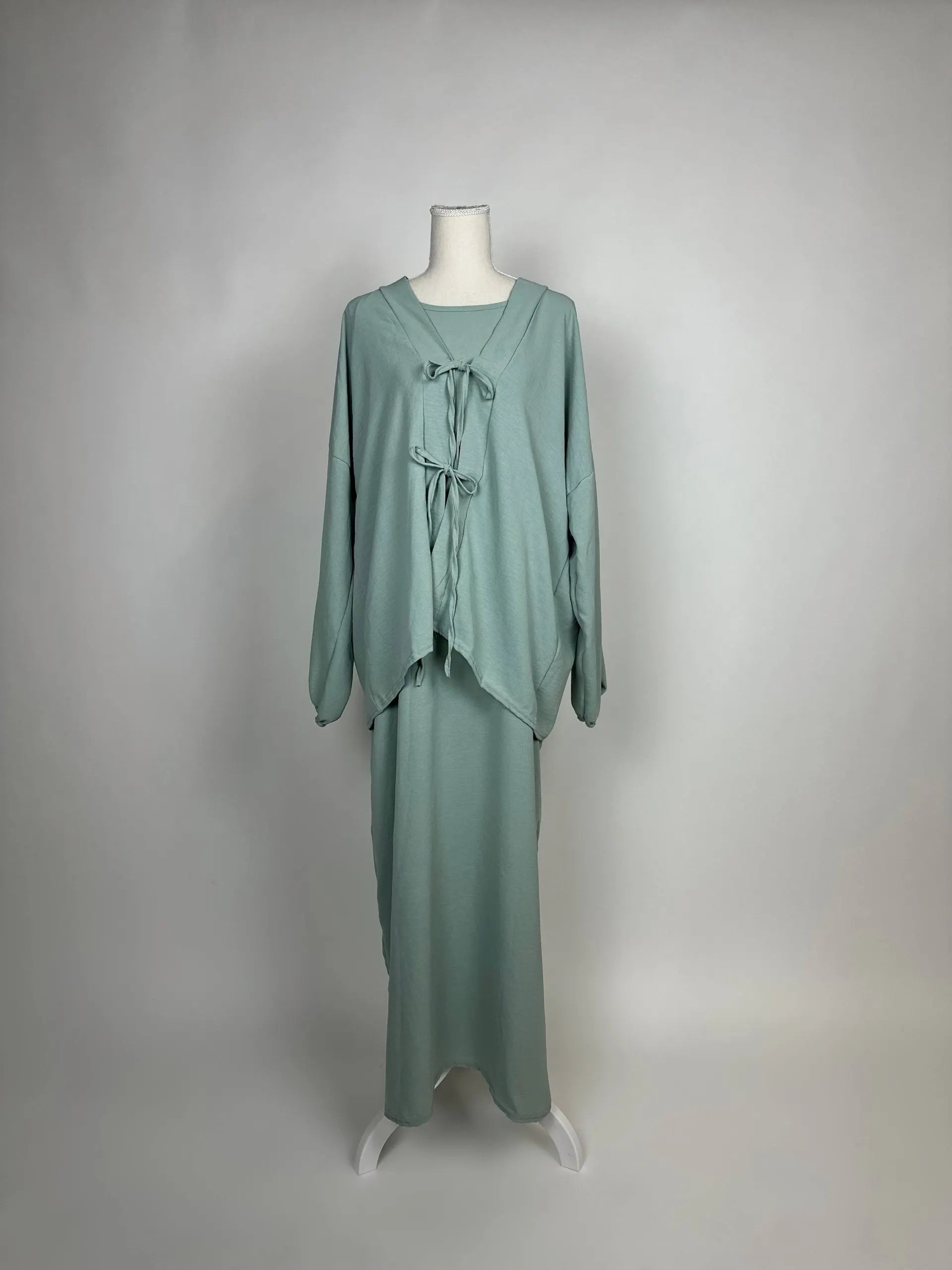 Salbeigrünes Abaya-Zweiteiler-Set aus Jersey im Modest-Stil mit Schleifen am Oberteil und Unterkleid, Vorderansicht.