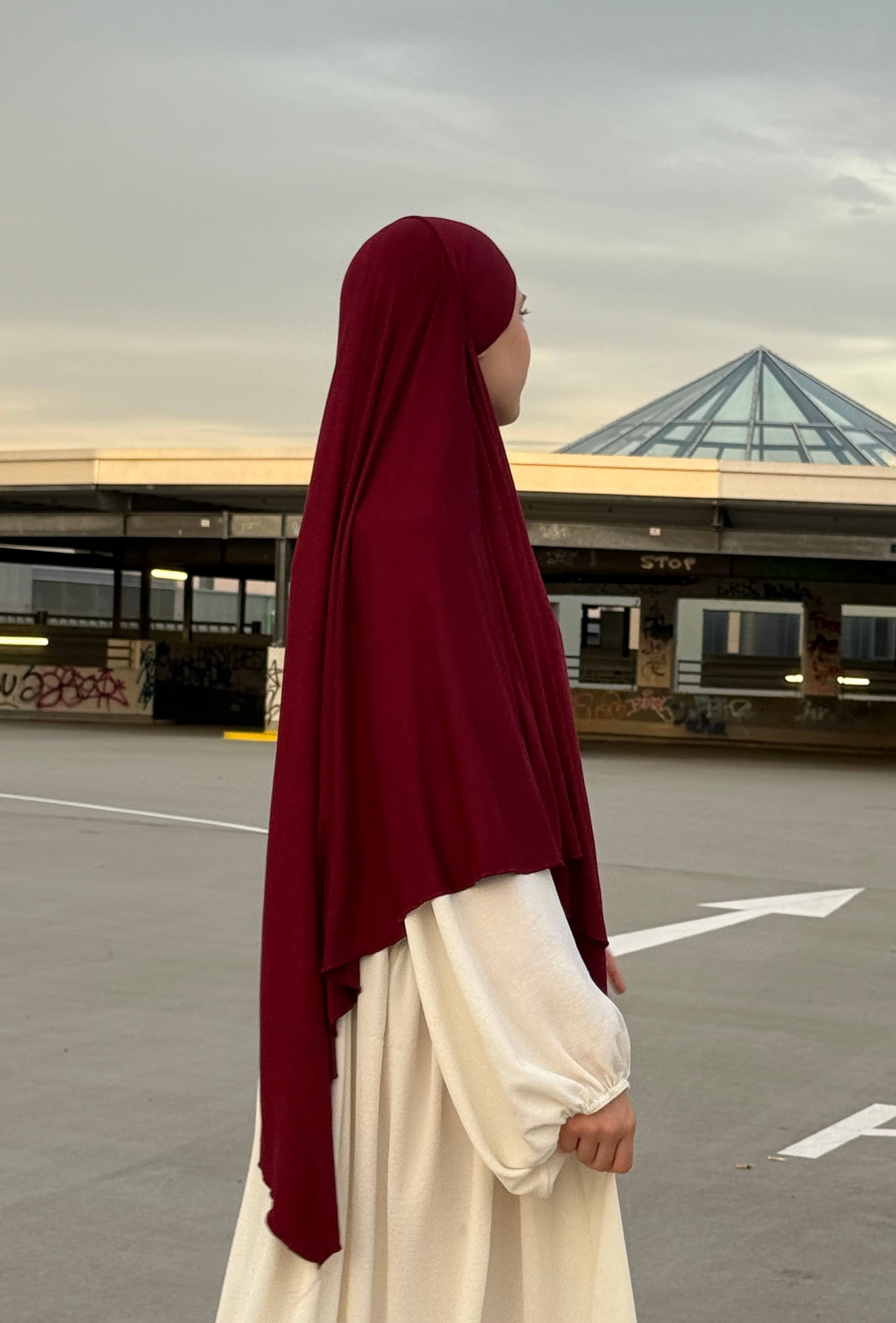 Jersey Khimar aus Viskose-Elastan in Bordeaux, seitliche Ansicht einer stehenden Person.