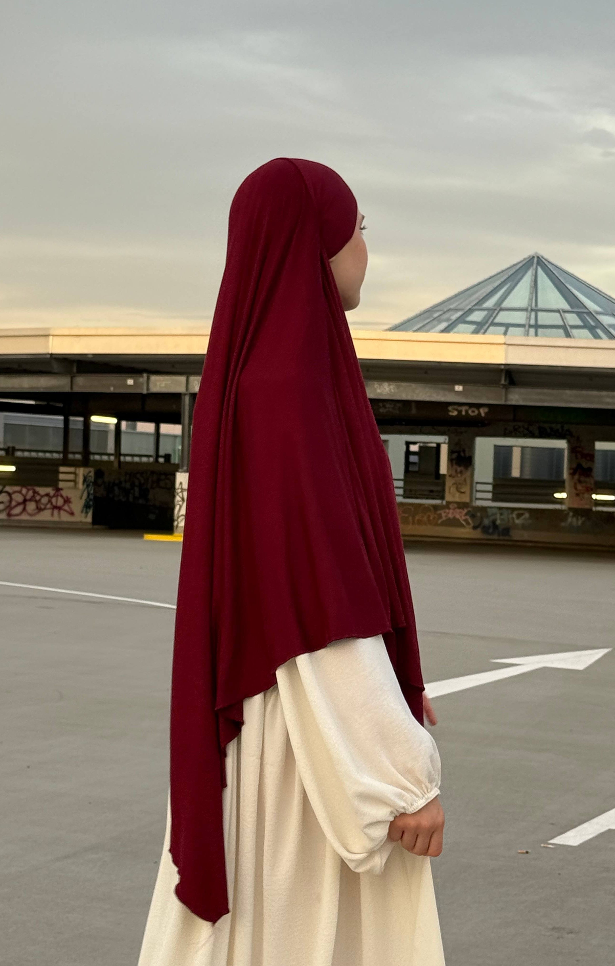 Jersey Khimar aus Viskose-Elastan in Bordeaux, seitliche Ansicht einer stehenden Person.