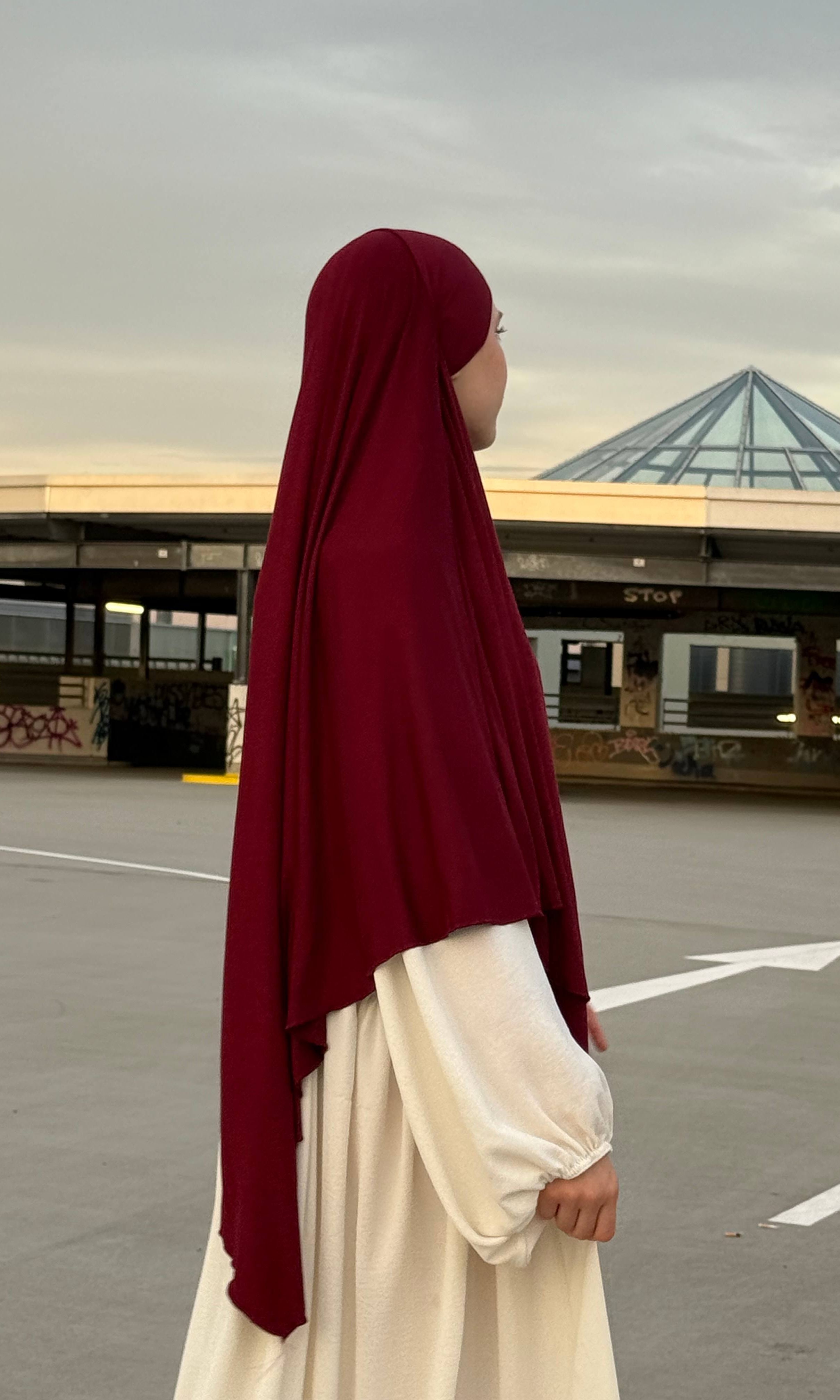 Jersey Khimar aus Viskose-Elastan in Bordeaux, seitliche Ansicht einer stehenden Person.