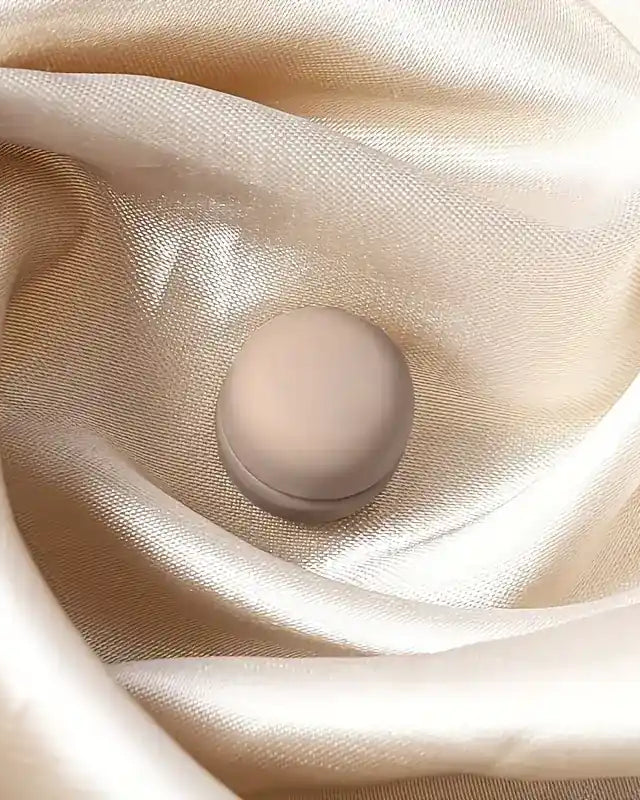 Beiger Hijab-Magnet, matt und rund, nadellos für starken Halt, auf champagnerfarbenem Satin-Hijab, Nahaufnahme