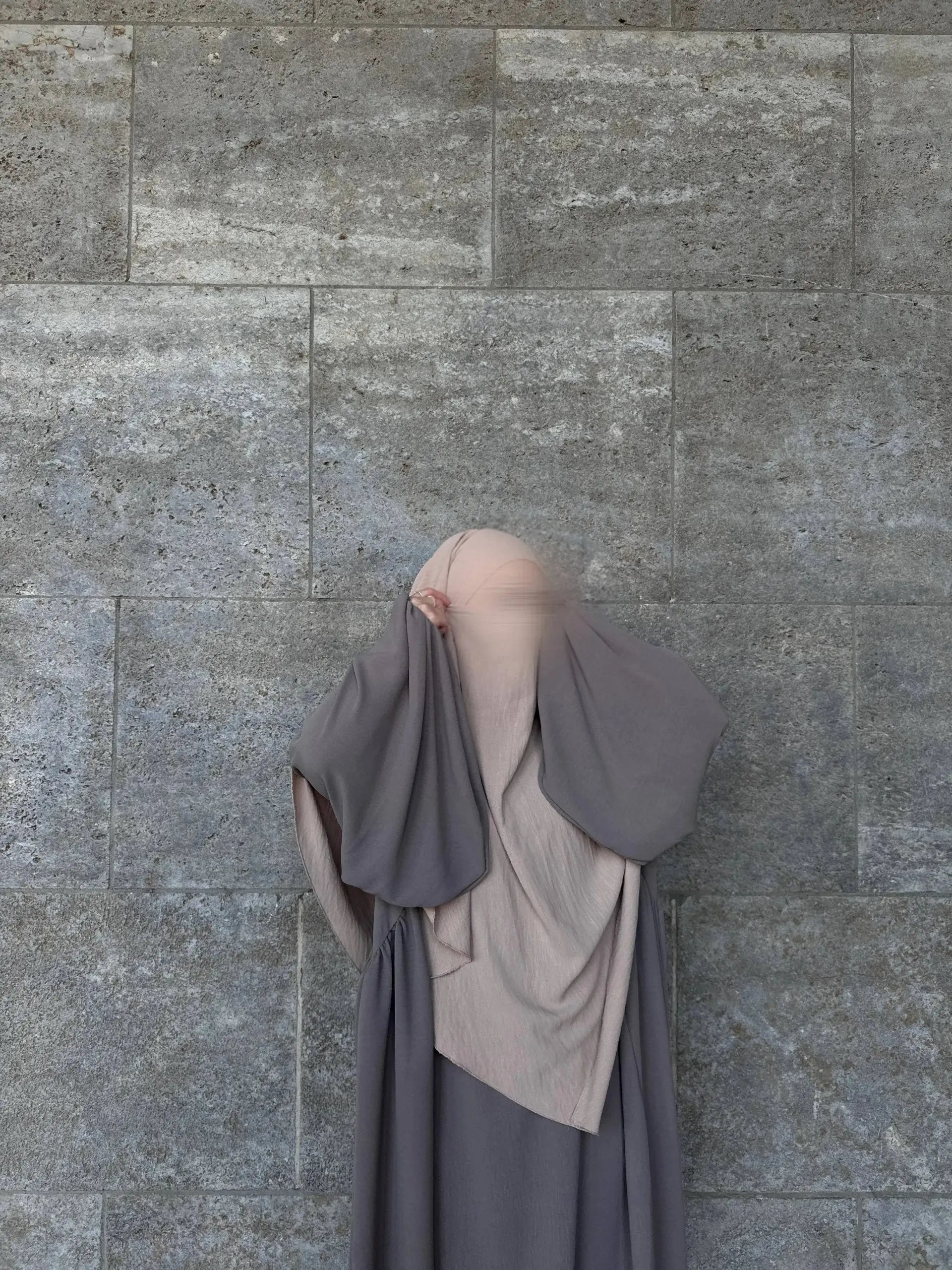 Die taubengraue Abaya Merve aus Jazz-Stoff zeigt weites, lagenartiges Draping und weite Ärmel in Vorderansicht.