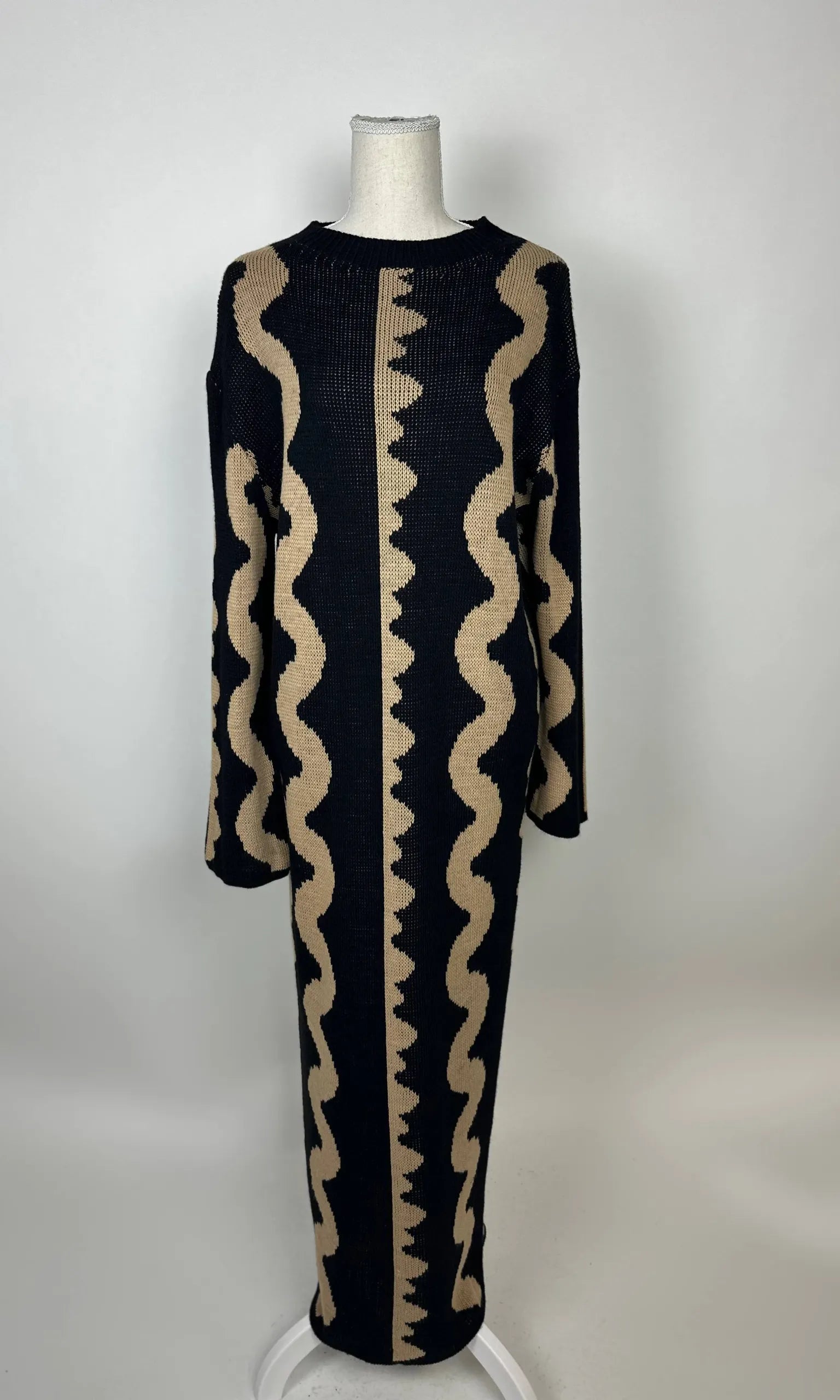 Schwarz-beiges Maxi Strickkleid aus Strick mit vertikalem Wellenmuster und langen Ärmeln, Vorderansicht auf Puppe