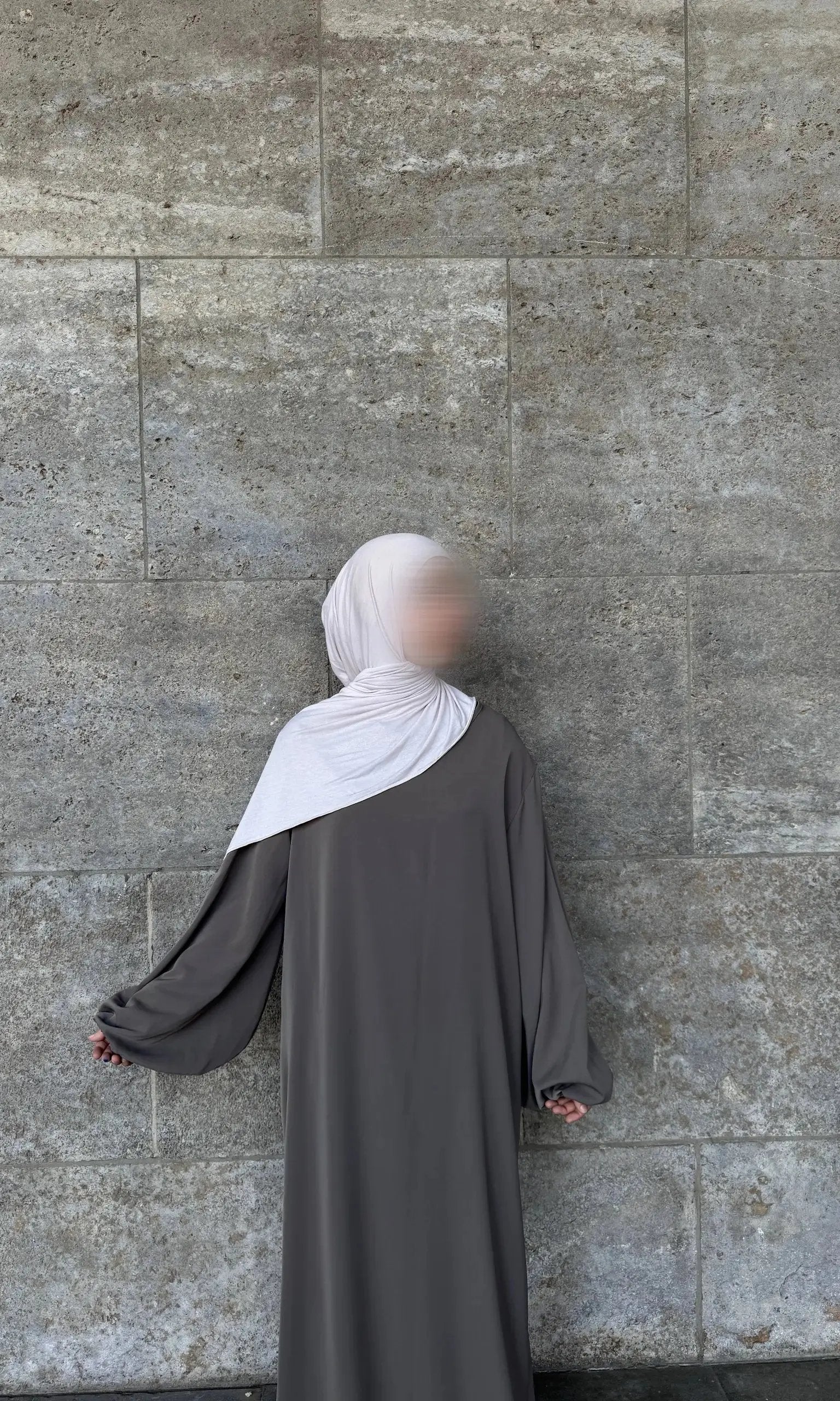 Eine graue Abaya aus Medina-Seide mit Ballonärmeln wird in der Rückansicht gezeigt.