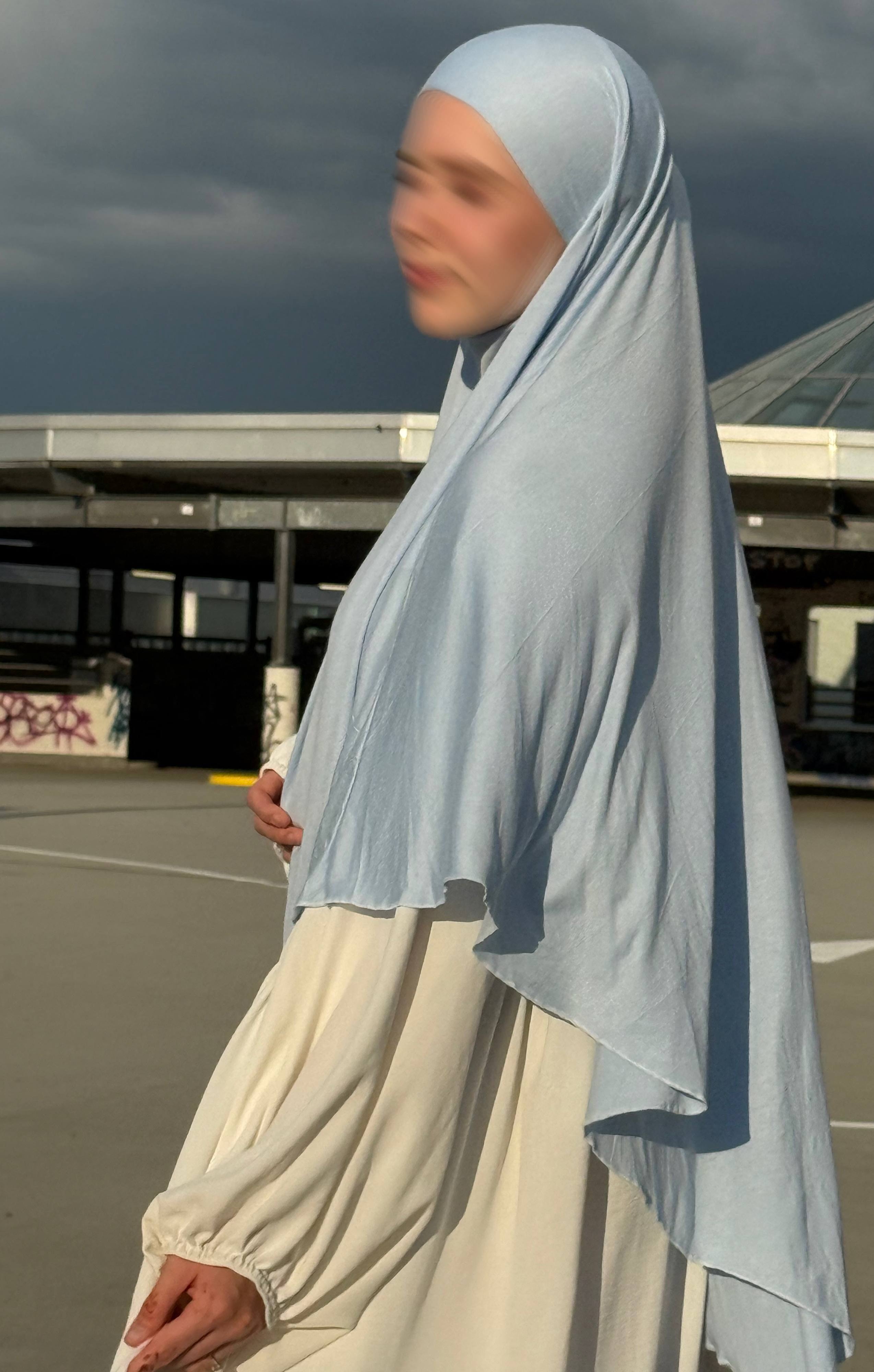 Jersey Khimar hellblau aus 95% Viskose und 5% Elastan, seitliche Ansicht mit langer Rückenpartie.