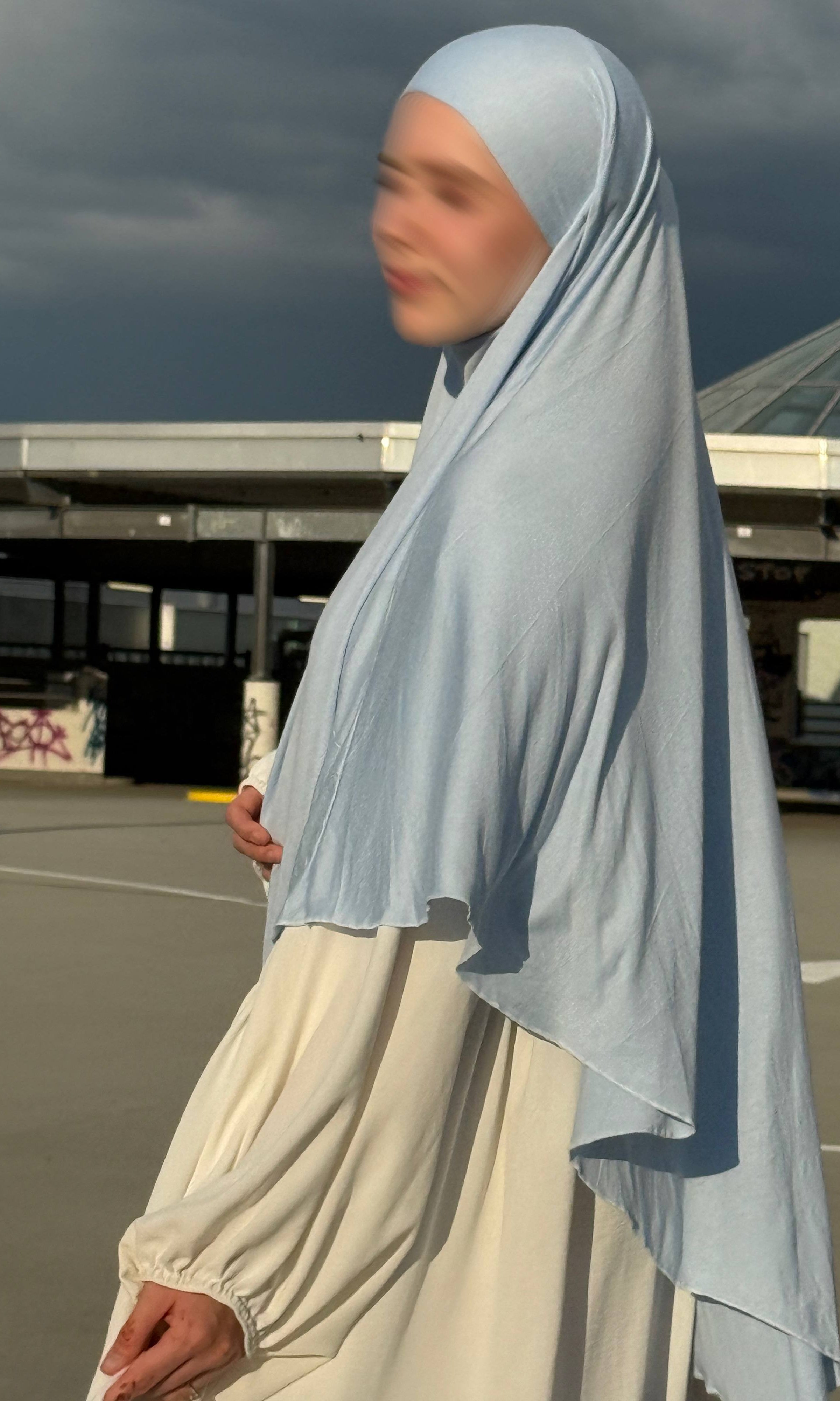 Jersey Khimar hellblau aus 95% Viskose und 5% Elastan, seitliche Ansicht mit langer Rückenpartie.