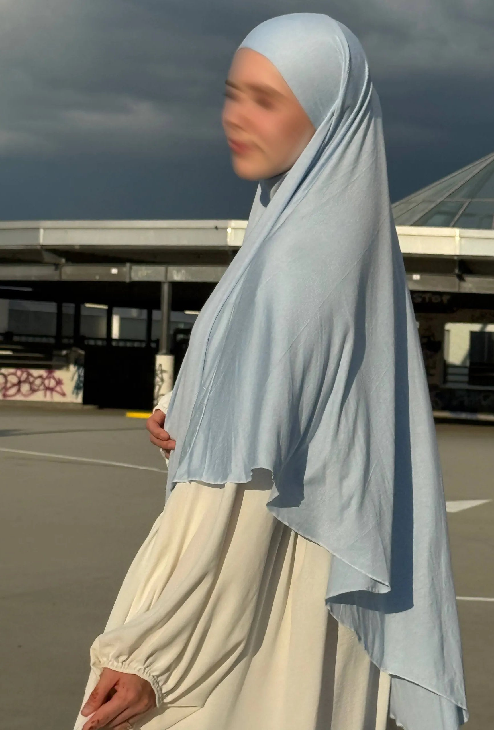 Jersey Khimar hellblau aus 95% Viskose und 5% Elastan, seitliche Ansicht mit langer Rückenpartie.