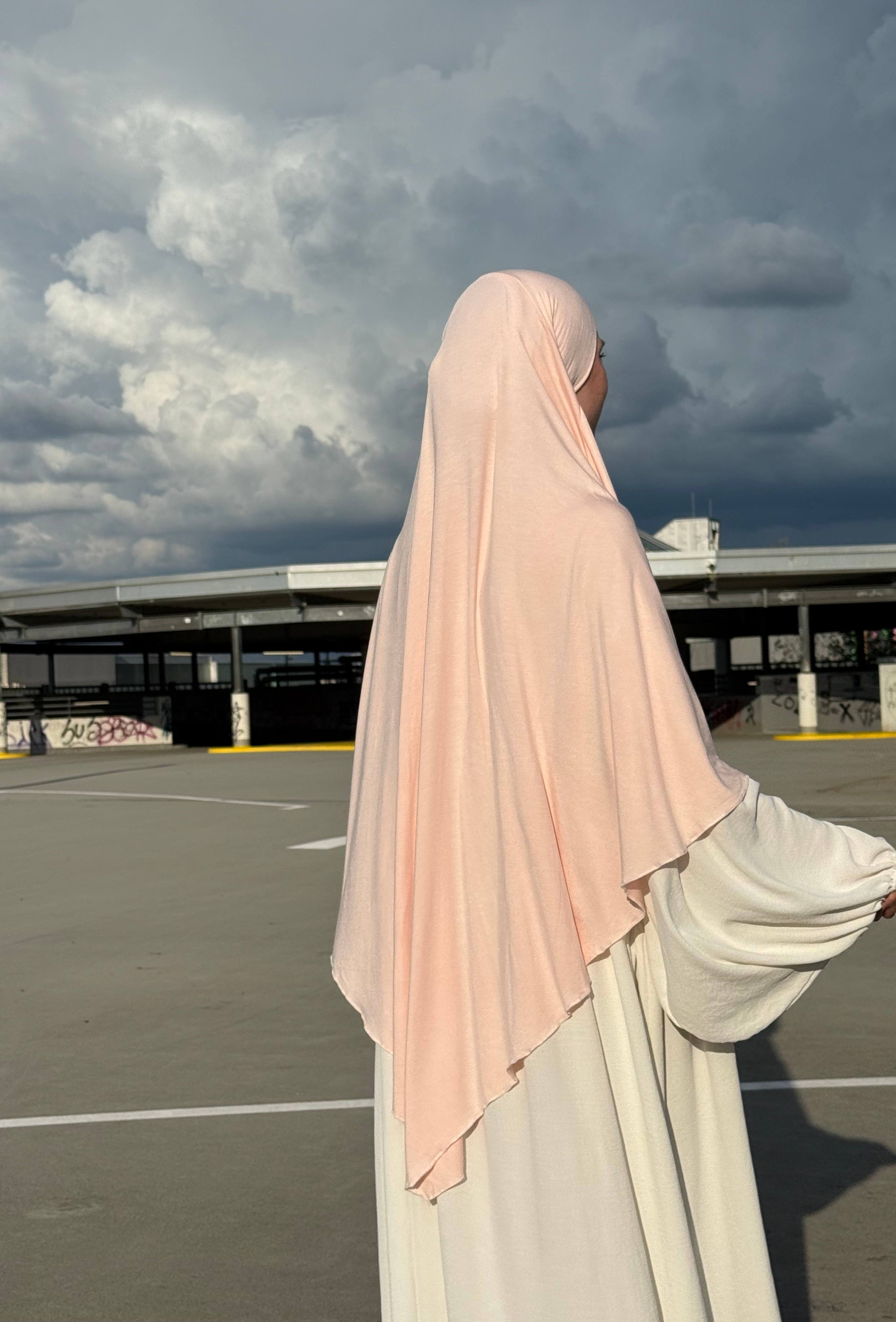 Ein Jersey Khimar in hellrosa aus Viskose-Elastan ist seitlich von hinten zu sehen.