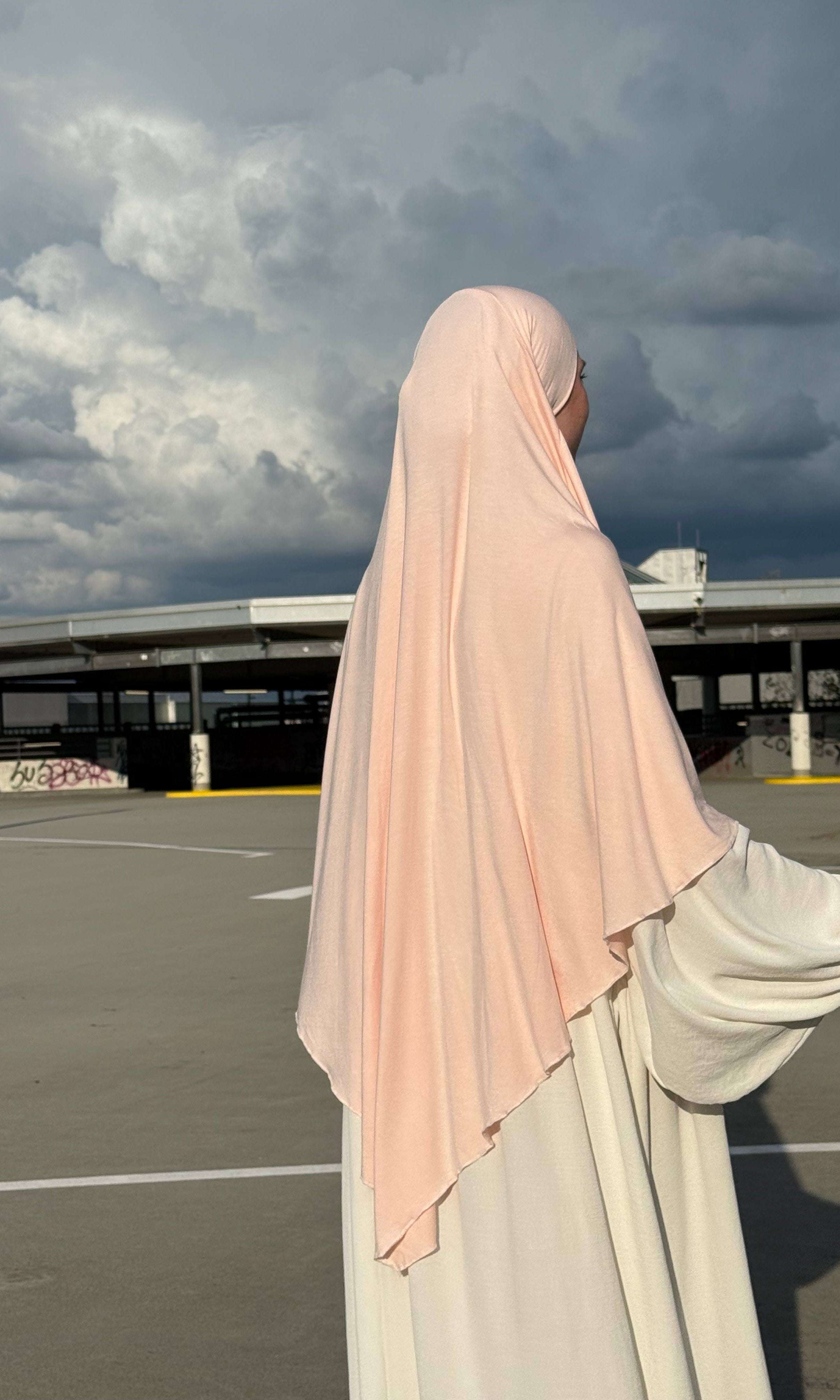 Ein Jersey Khimar in hellrosa aus Viskose-Elastan ist seitlich von hinten zu sehen.