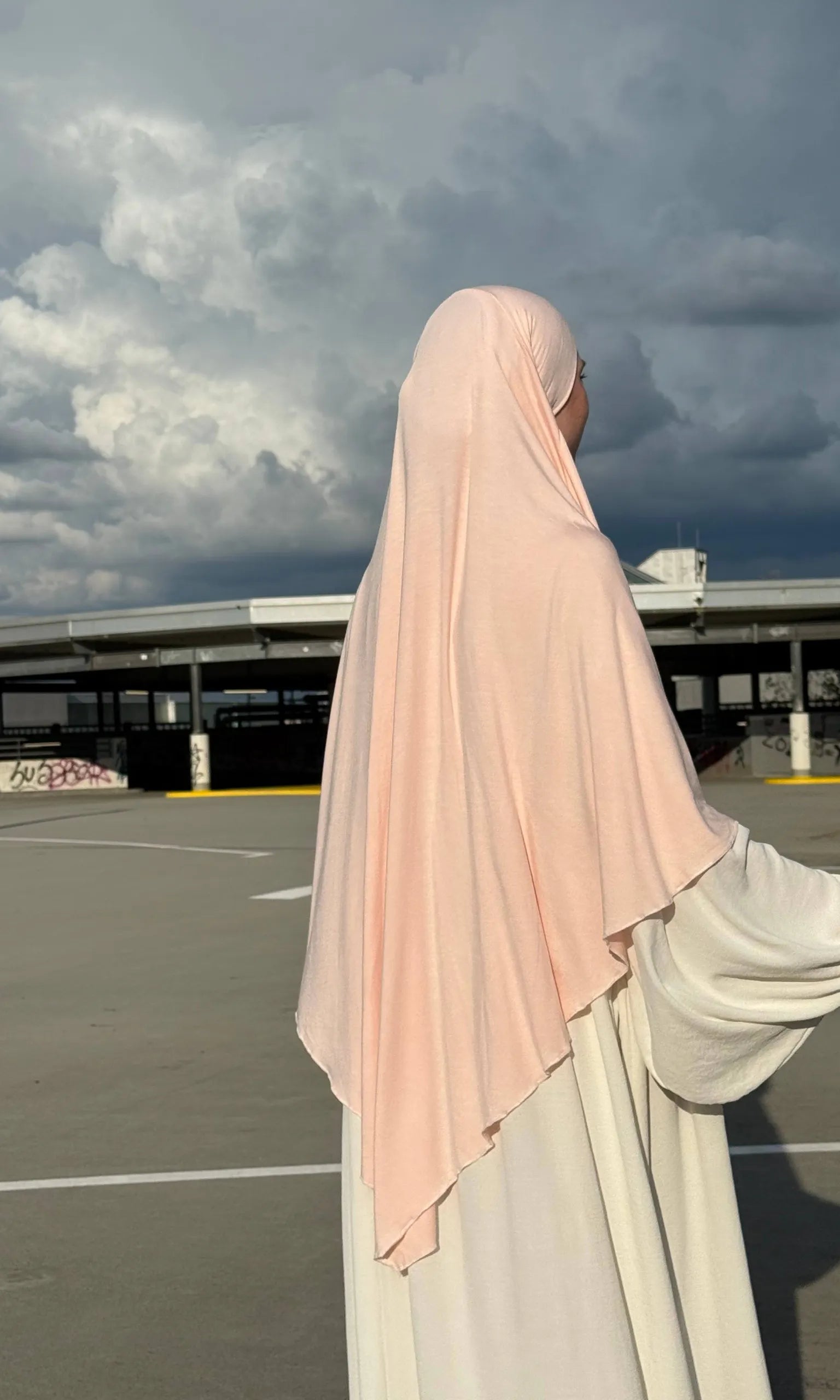 Ein Jersey Khimar in hellrosa aus Viskose-Elastan ist seitlich von hinten zu sehen.