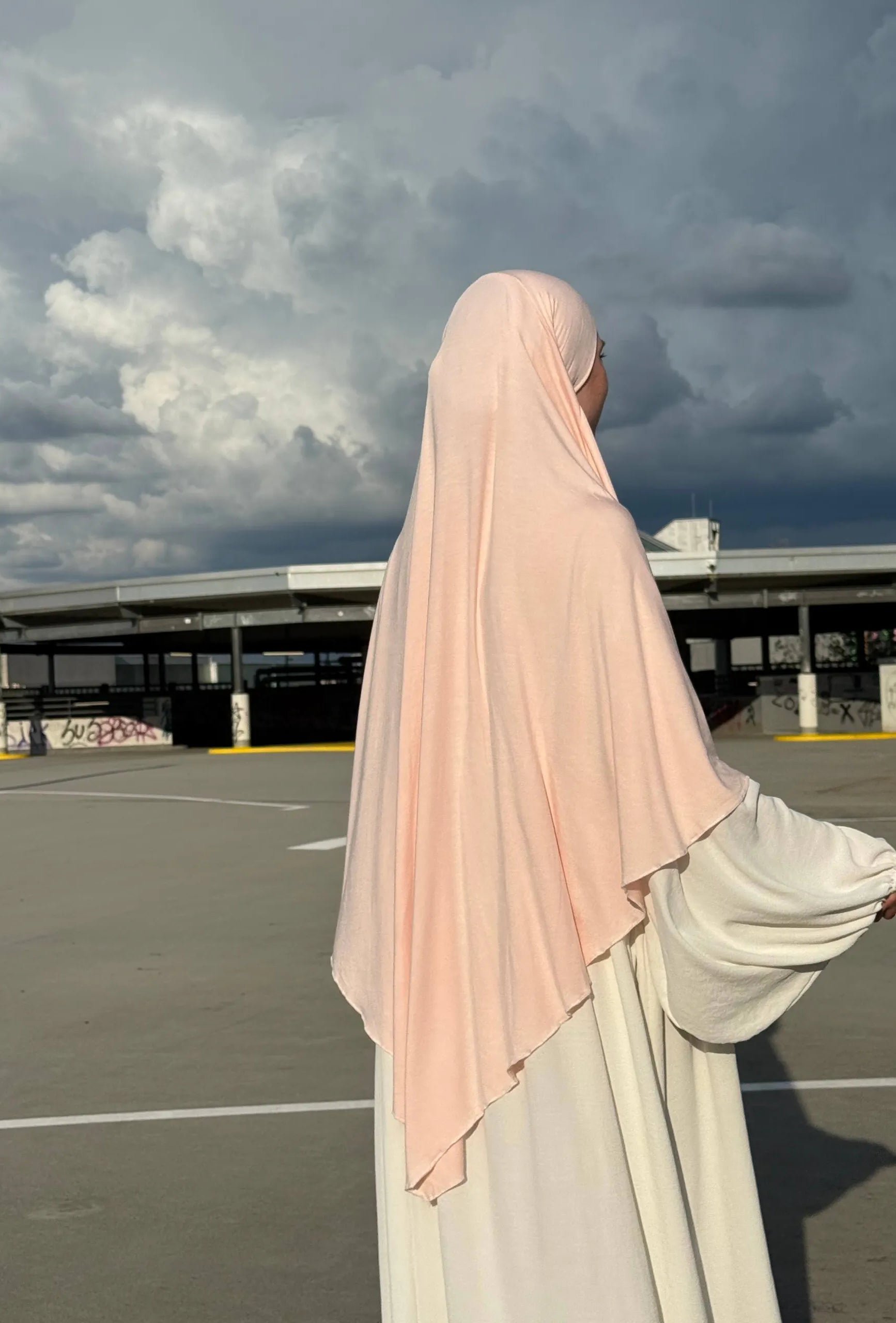 Ein Jersey Khimar in hellrosa aus Viskose-Elastan ist seitlich von hinten zu sehen.