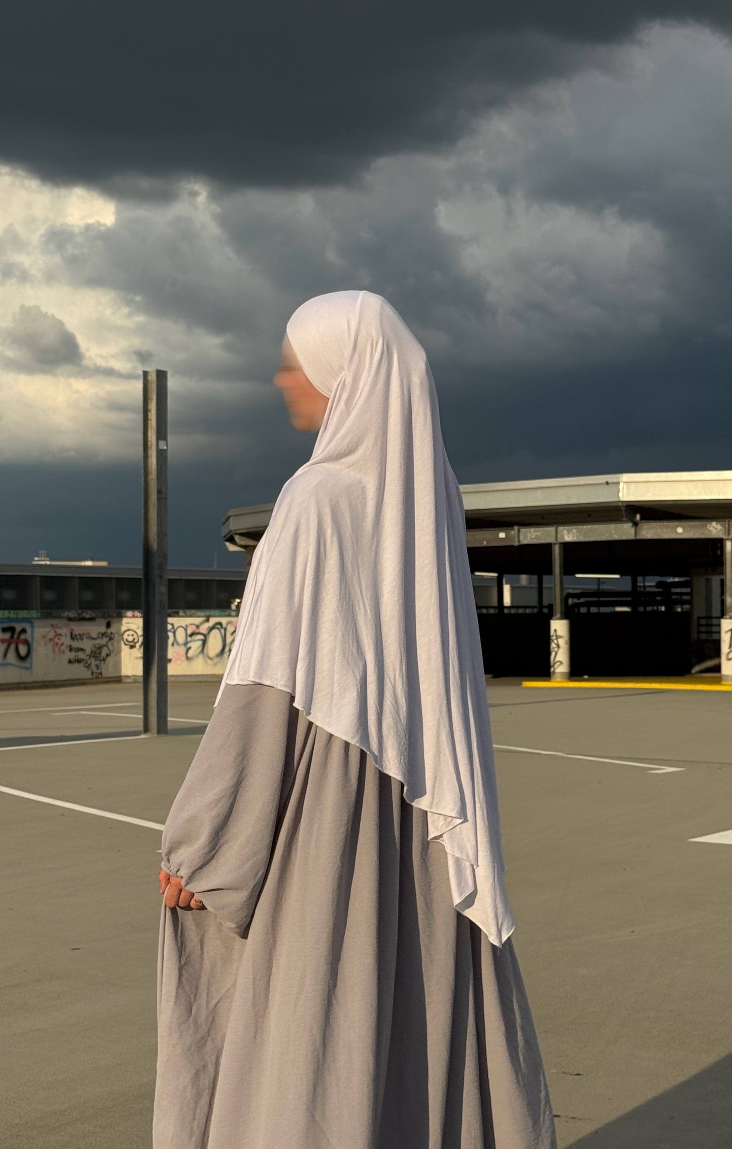 Jersey-Khimar in hellbeige aus 95% Viskose/5% Elastan, seitliche Ansicht mit deutlich fallendem Rückenteil.