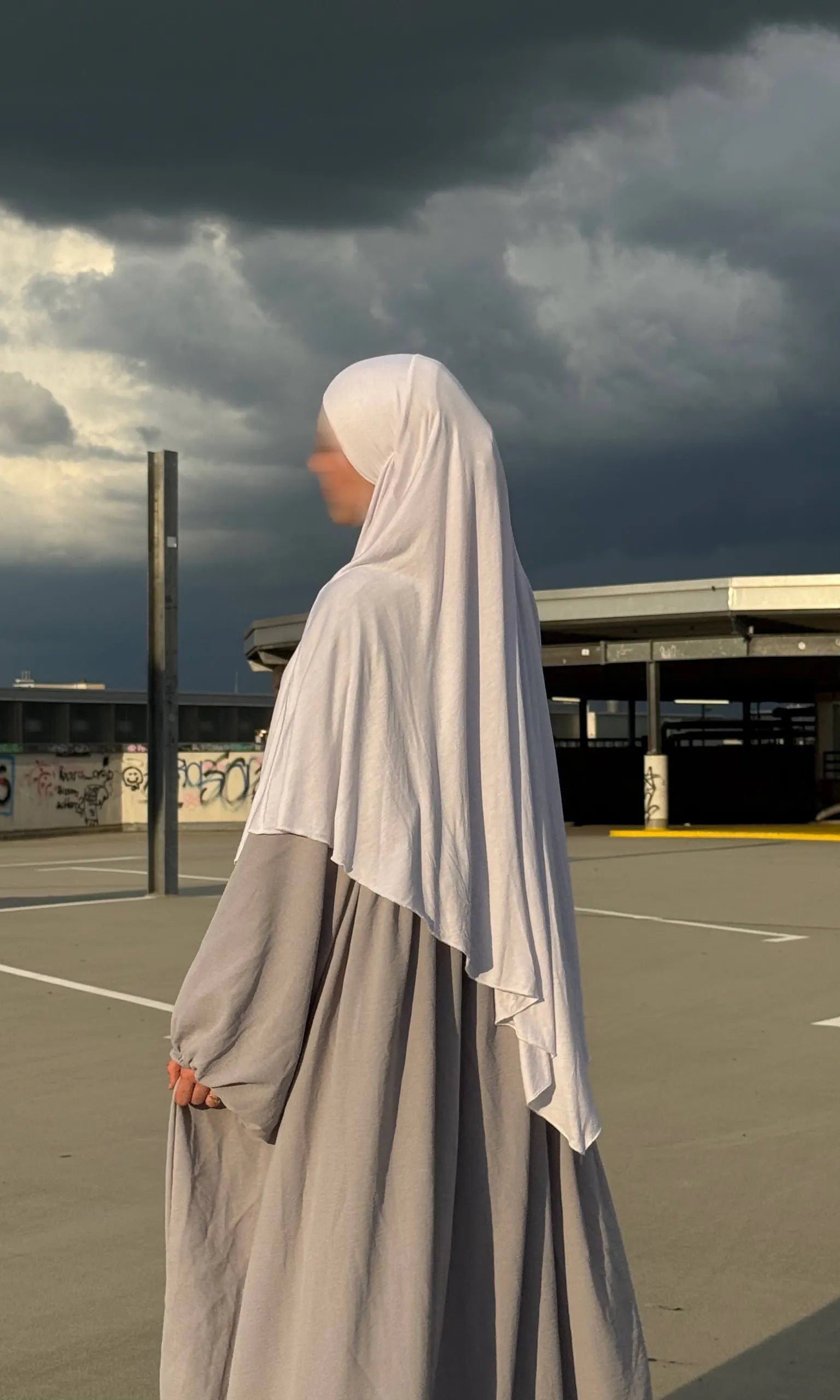 Jersey-Khimar in hellbeige aus 95% Viskose/5% Elastan, seitliche Ansicht mit deutlich fallendem Rückenteil.