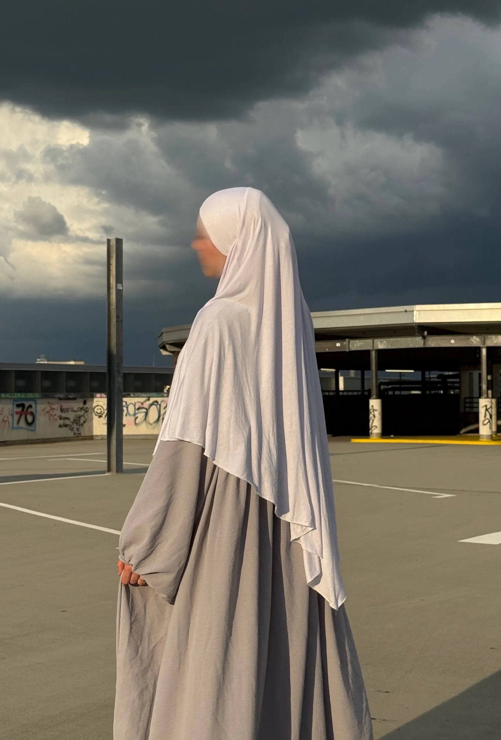 Jersey-Khimar in hellbeige aus 95% Viskose/5% Elastan, seitliche Ansicht mit deutlich fallendem Rückenteil.