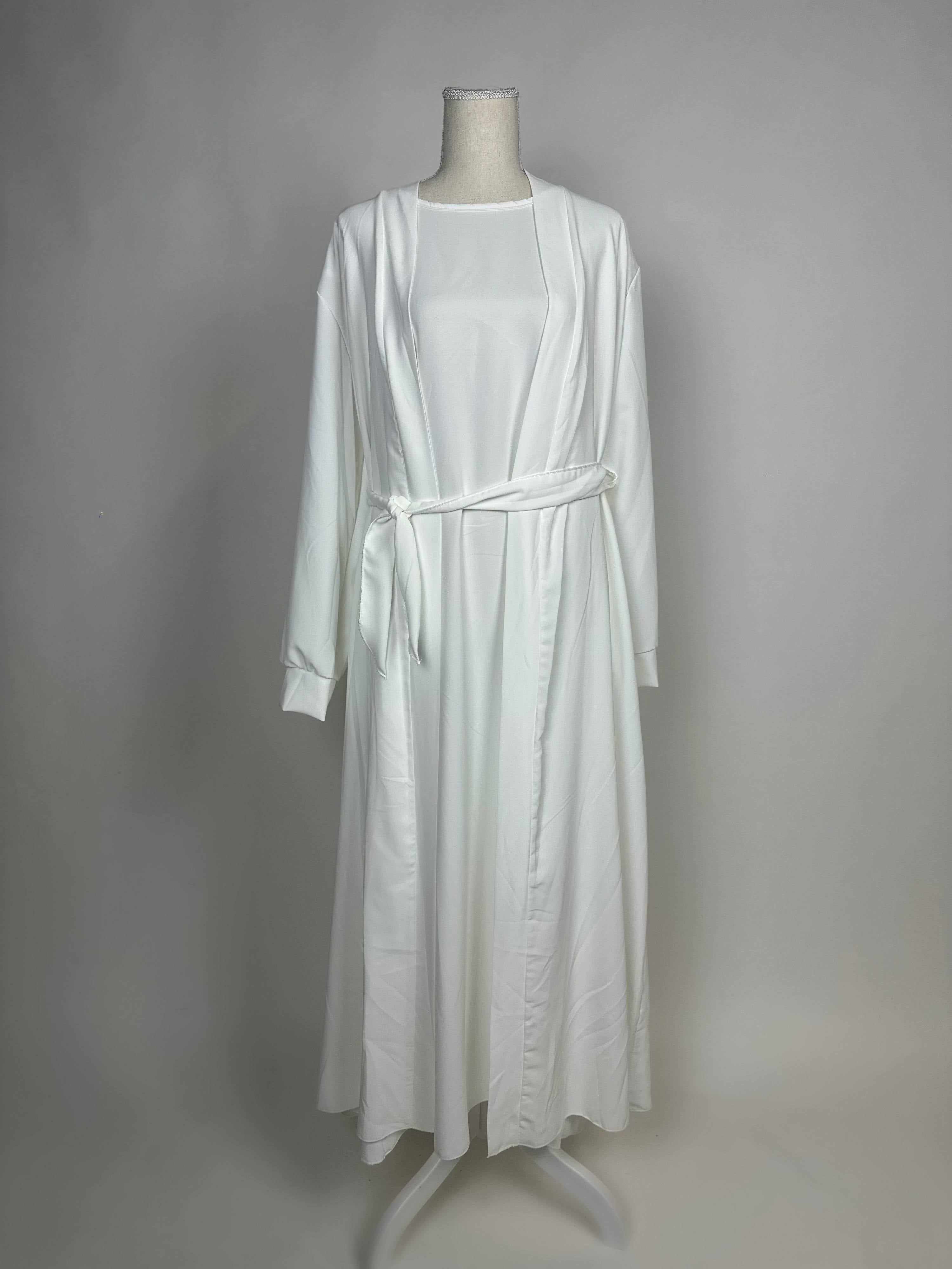 Eine weiße Open-Abaya im Dubai-Stil aus Medina-Seide mit Unterkleid und Bindegürtel wird in Vorderansicht gezeigt.