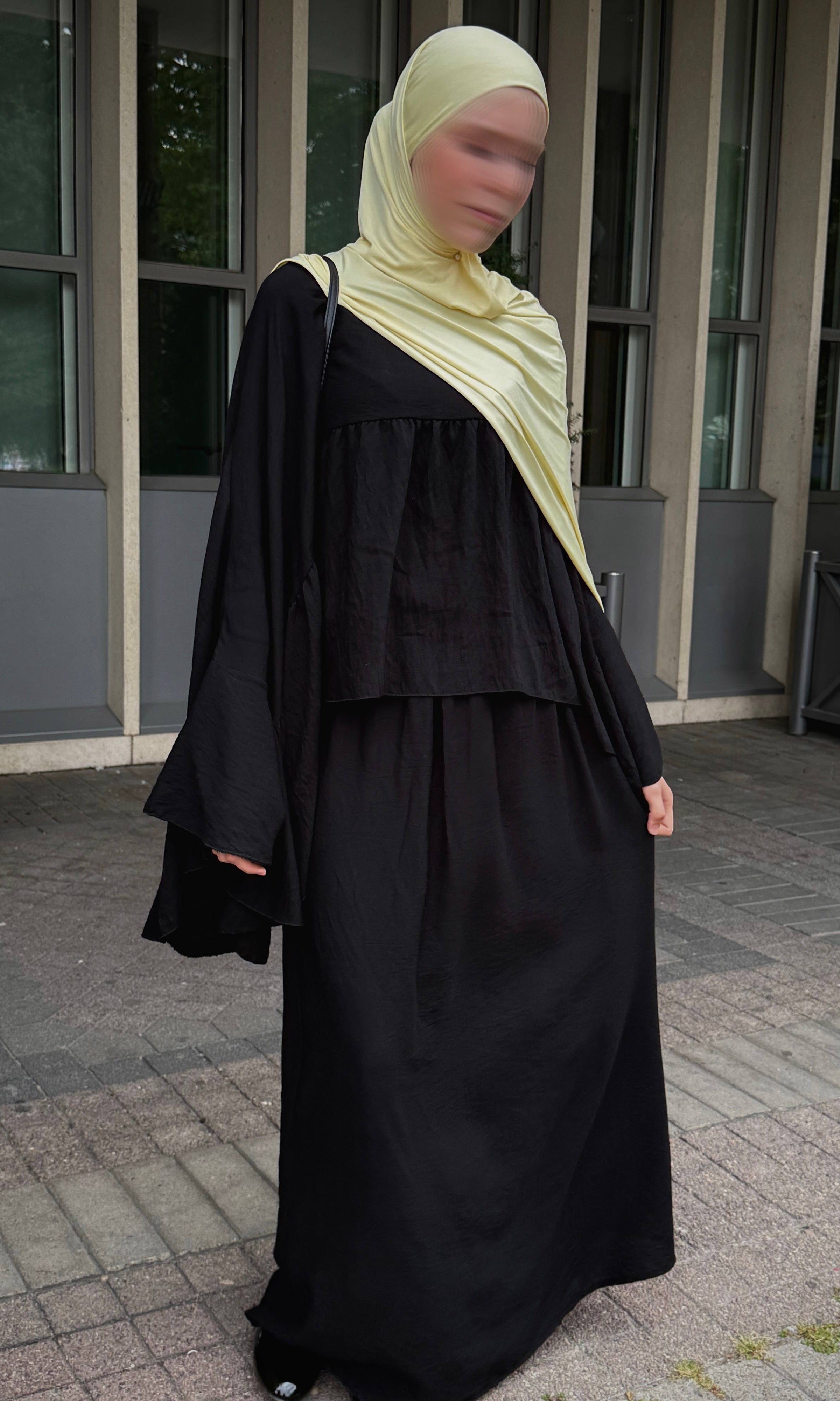 schwarzer zweiteiler mit weitem oberteil, glockenärmeln und langem maxirock, frontansicht