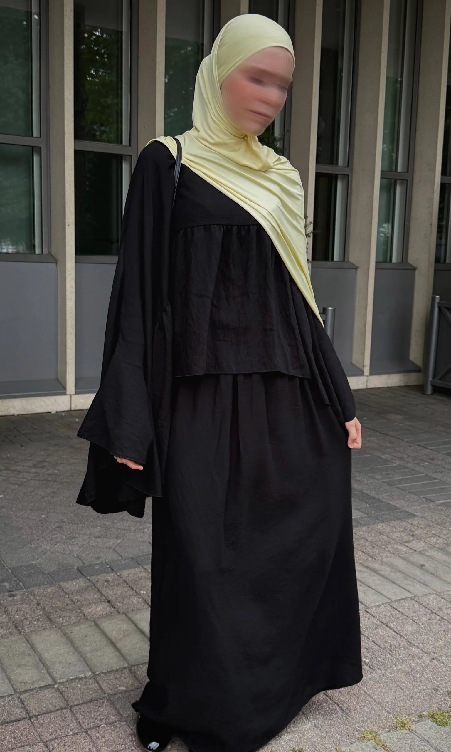 schwarzer zweiteiler mit weitem oberteil, glockenärmeln und langem maxirock, frontansicht