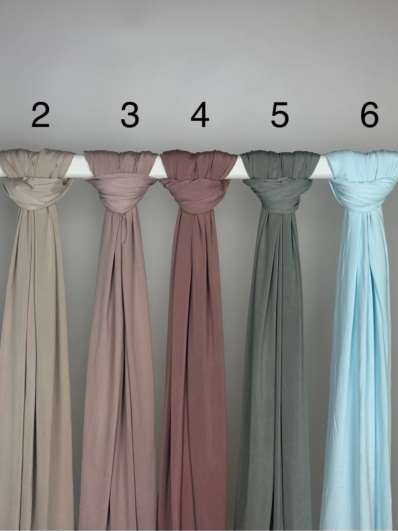 Mehrfarbiger Liquid-Jersey Hijab, shiny, rutschfest und atmungsaktiv, Modest Abaya Stil, hängend auf Stange, Frontansicht