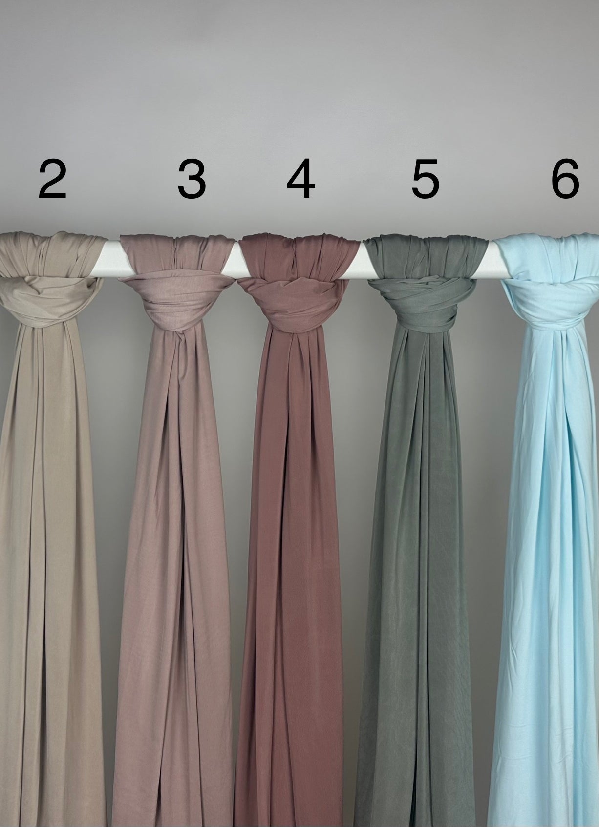 Mehrfarbiger Liquid-Jersey Hijab, shiny, rutschfest und atmungsaktiv, Modest Abaya Stil, hängend auf Stange, Frontansicht