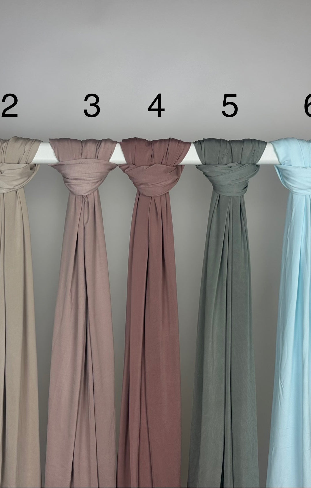 Mehrfarbiger Liquid-Jersey Hijab, shiny, rutschfest und atmungsaktiv, Modest Abaya Stil, hängend auf Stange, Frontansicht