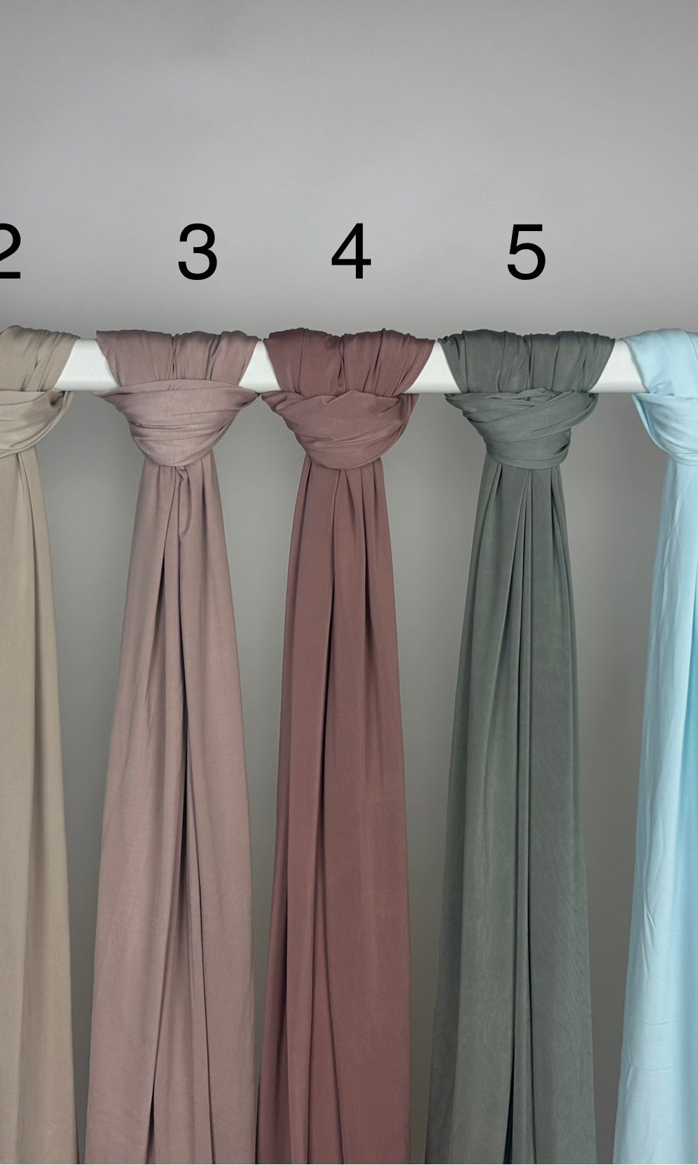 Mehrfarbiger Liquid-Jersey Hijab, shiny, rutschfest und atmungsaktiv, Modest Abaya Stil, hängend auf Stange, Frontansicht