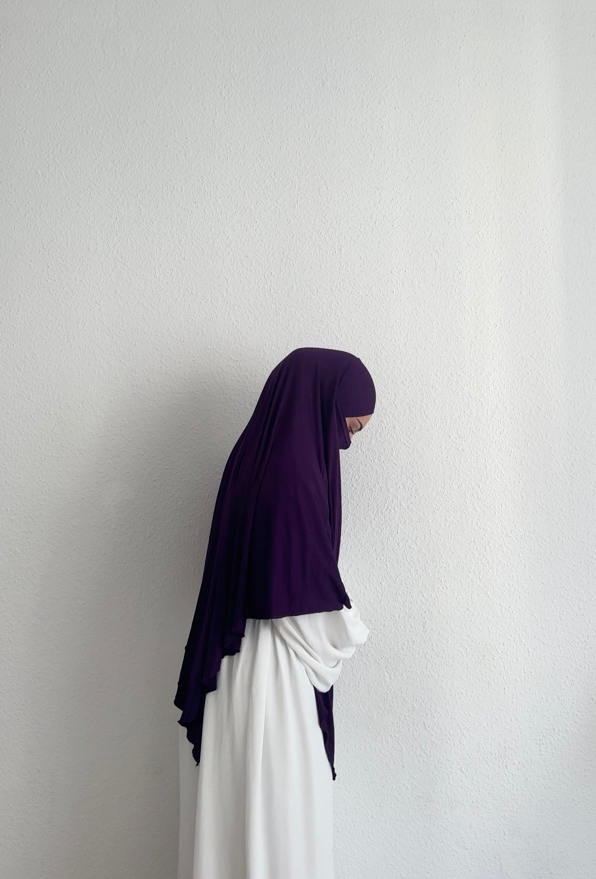 Jersey Khimar in dunklem Violett aus Viskose‑Elastan, seitliche Ansicht an einer stehenden Person.
