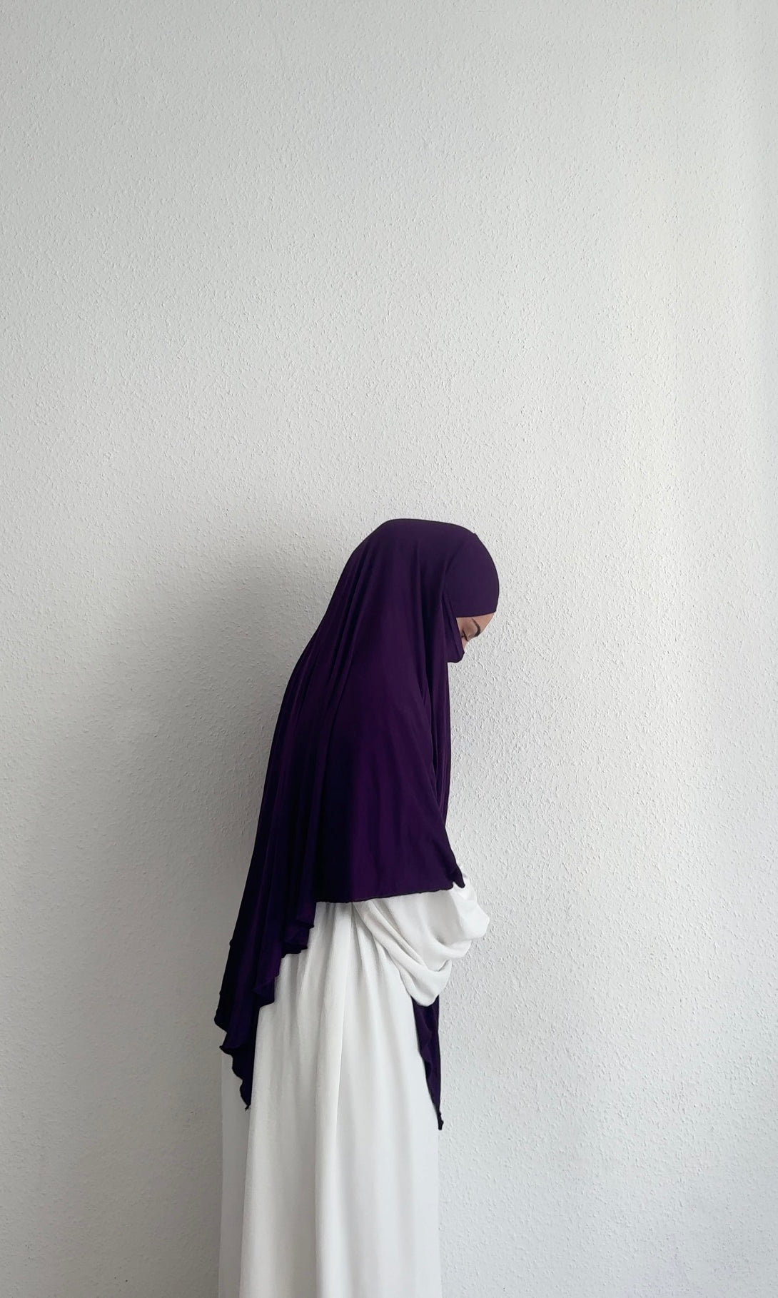 Jersey Khimar in dunklem Violett aus Viskose‑Elastan, seitliche Ansicht an einer stehenden Person.