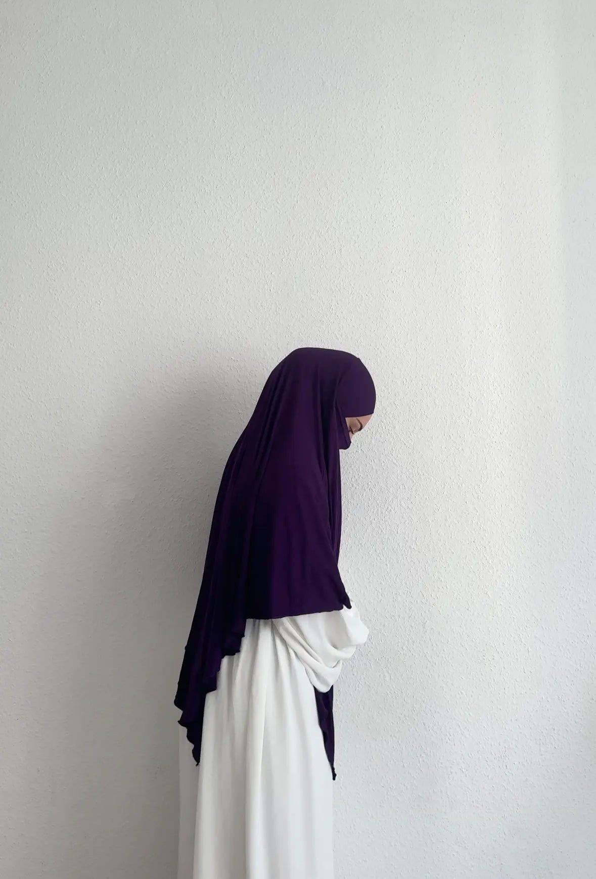 Jersey Khimar in dunklem Violett aus Viskose‑Elastan, seitliche Ansicht an einer stehenden Person.
