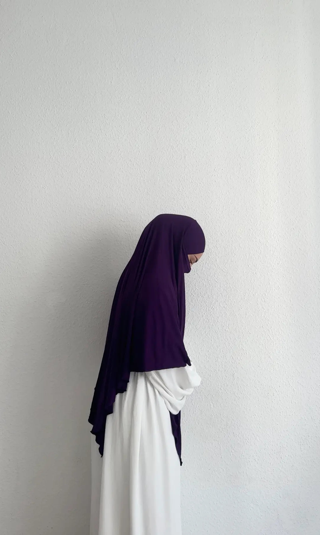 Jersey Khimar in dunklem Violett aus Viskose‑Elastan, seitliche Ansicht an einer stehenden Person.