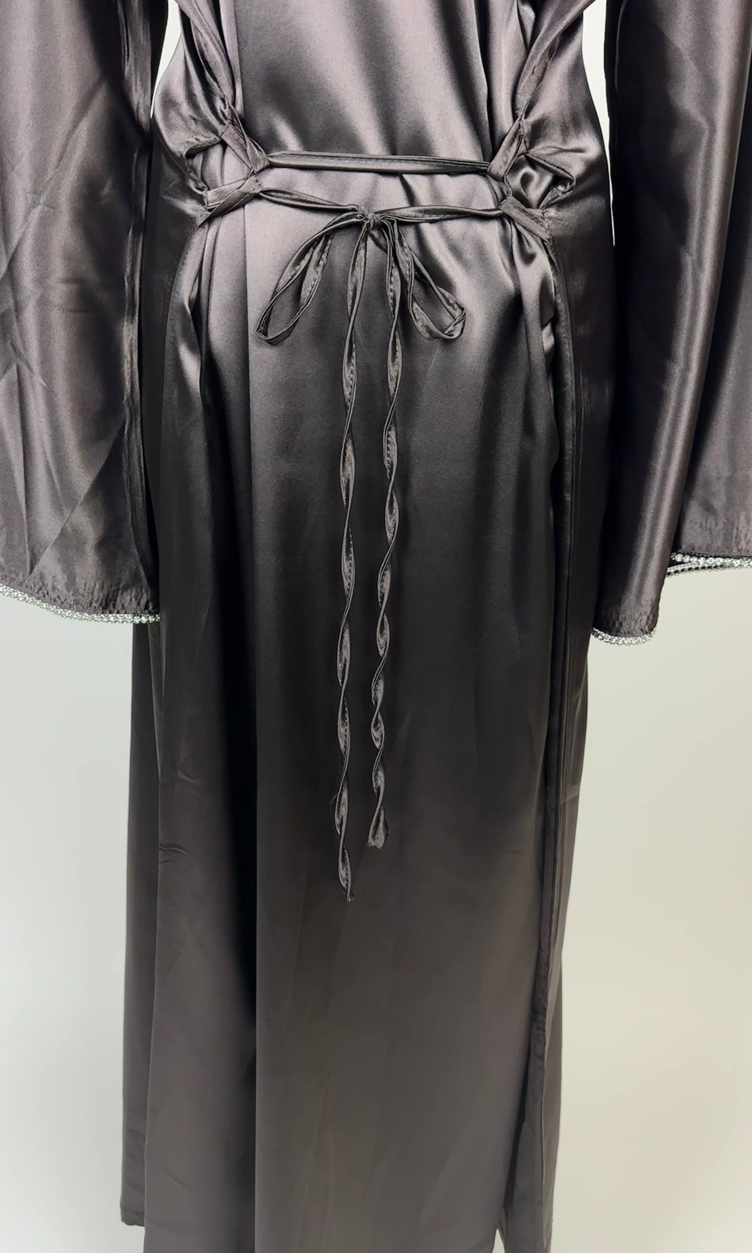 Graphitgraue Abaya aus Polyester in Satin-Optik mit Taillenschnüren und Perlenbesatz an den Ärmeln, Vorderansicht