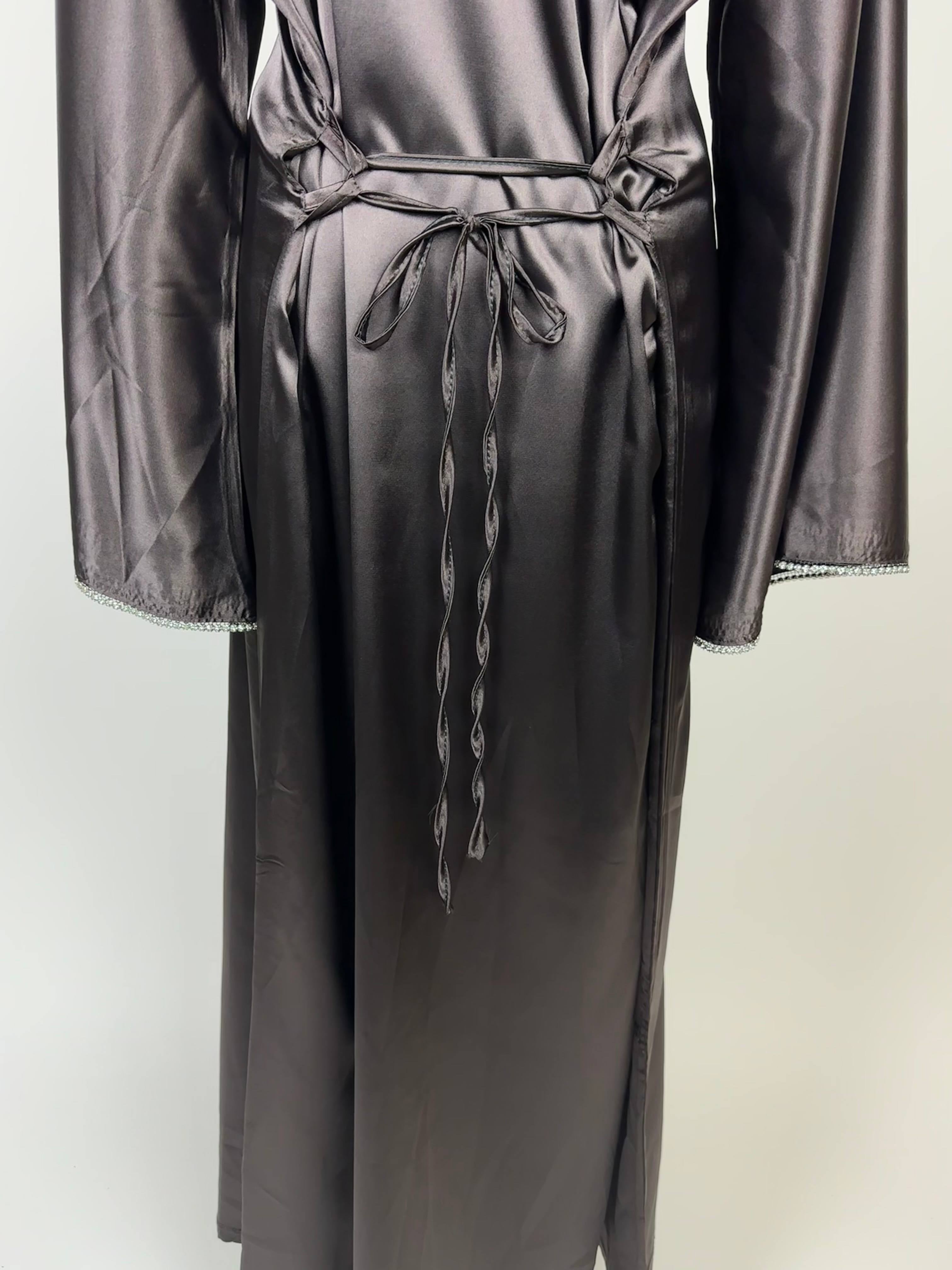 Graphitgraue Abaya aus Polyester in Satin-Optik mit Taillenschnüren und Perlenbesatz an den Ärmeln, Vorderansicht