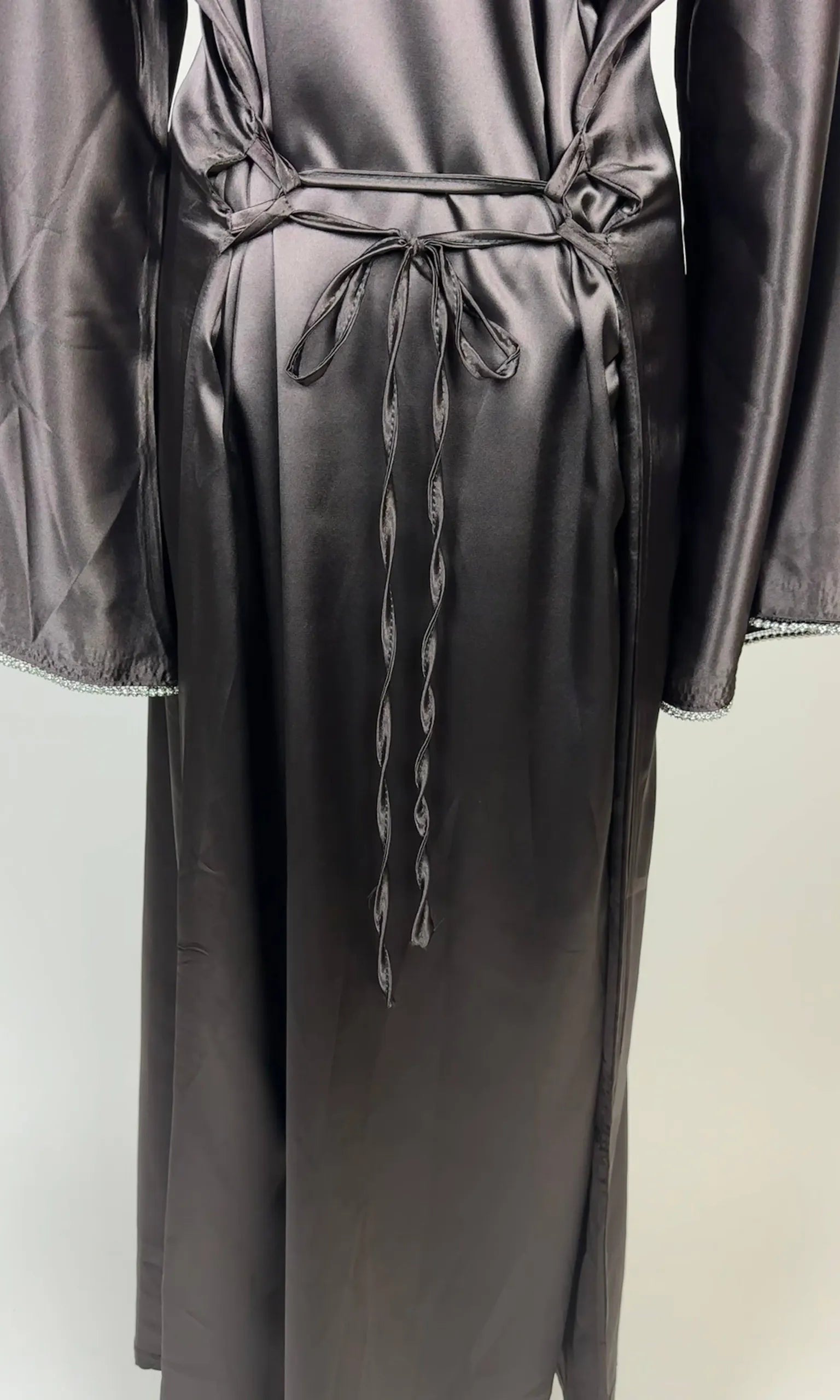 Graphitgraue Abaya aus Polyester in Satin-Optik mit Taillenschnüren und Perlenbesatz an den Ärmeln, Vorderansicht