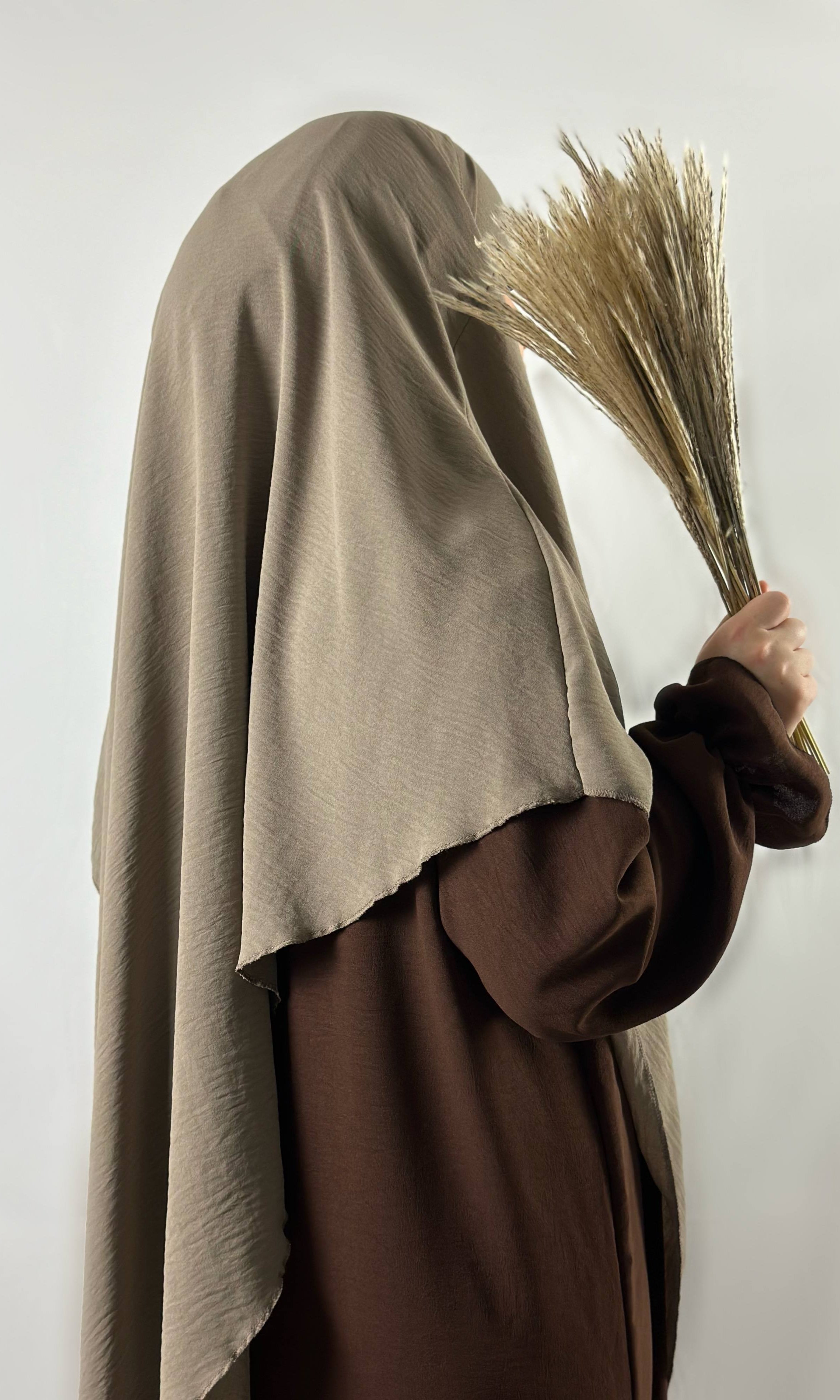 abaya in dunkelbraunem jazz-stoff mit rüschenärmeln, seiten-/rückansicht, getragen mit beigem khimar