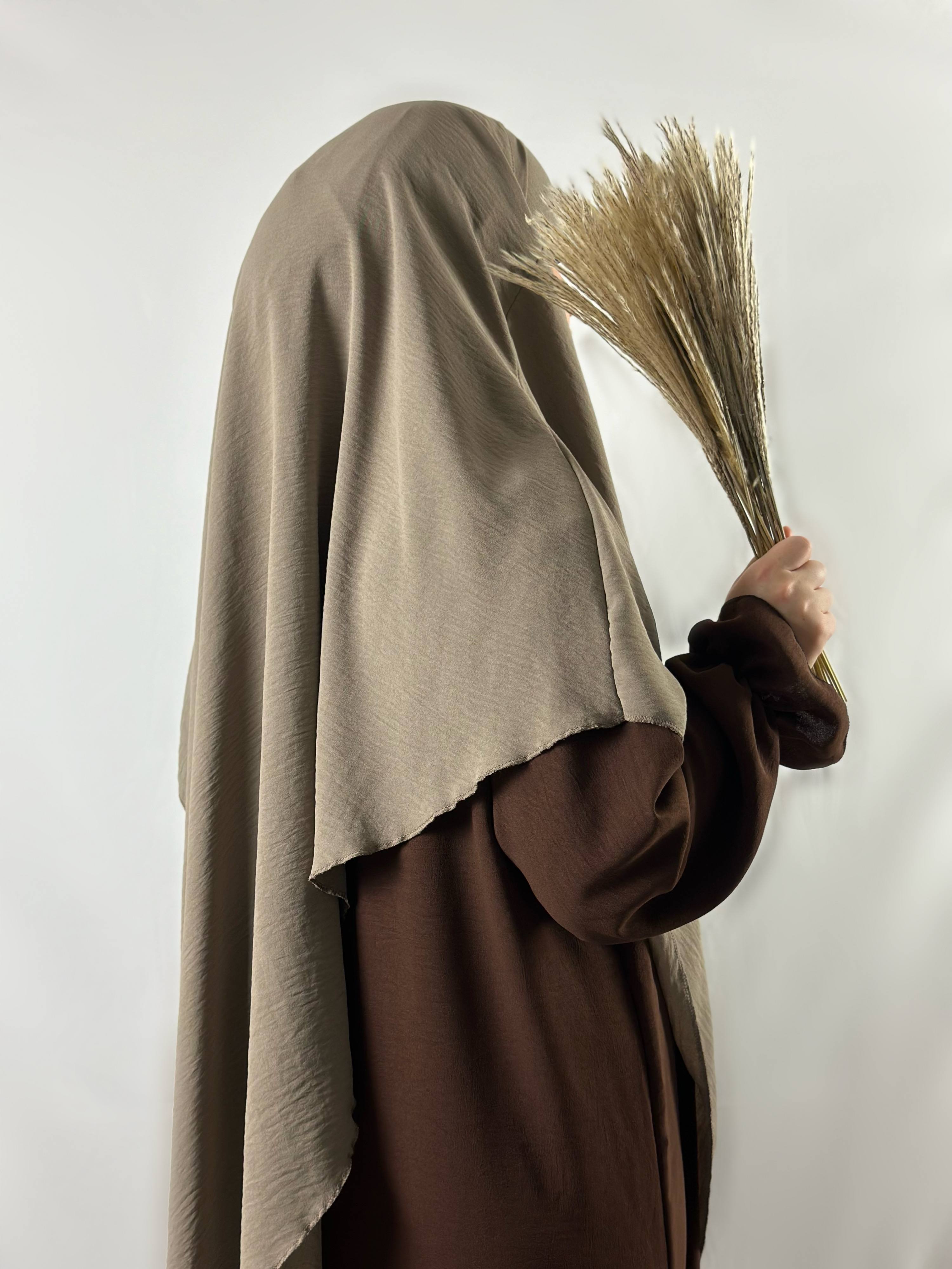 abaya in dunkelbraunem jazz-stoff mit rüschenärmeln, seiten-/rückansicht, getragen mit beigem khimar