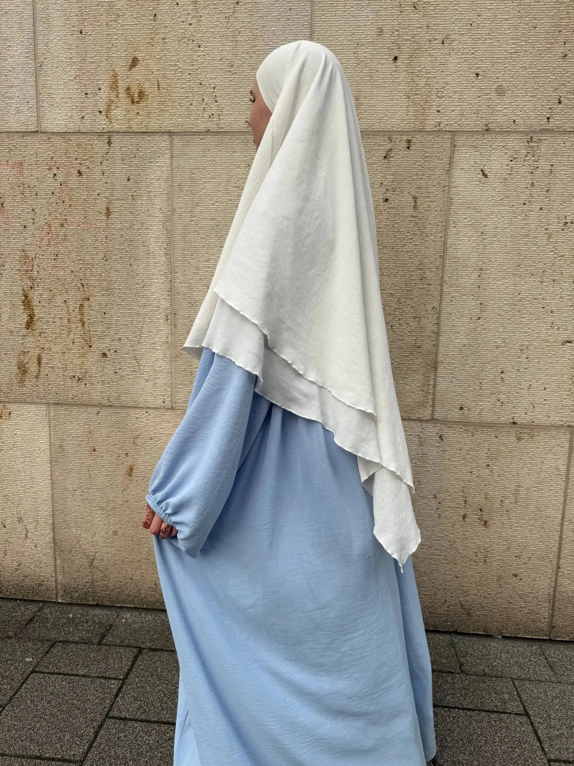 abaya aus hellblauem jazzstoff, weit geschnitten mit elastischem ärmelbund, seitenansicht unter weißem khimar