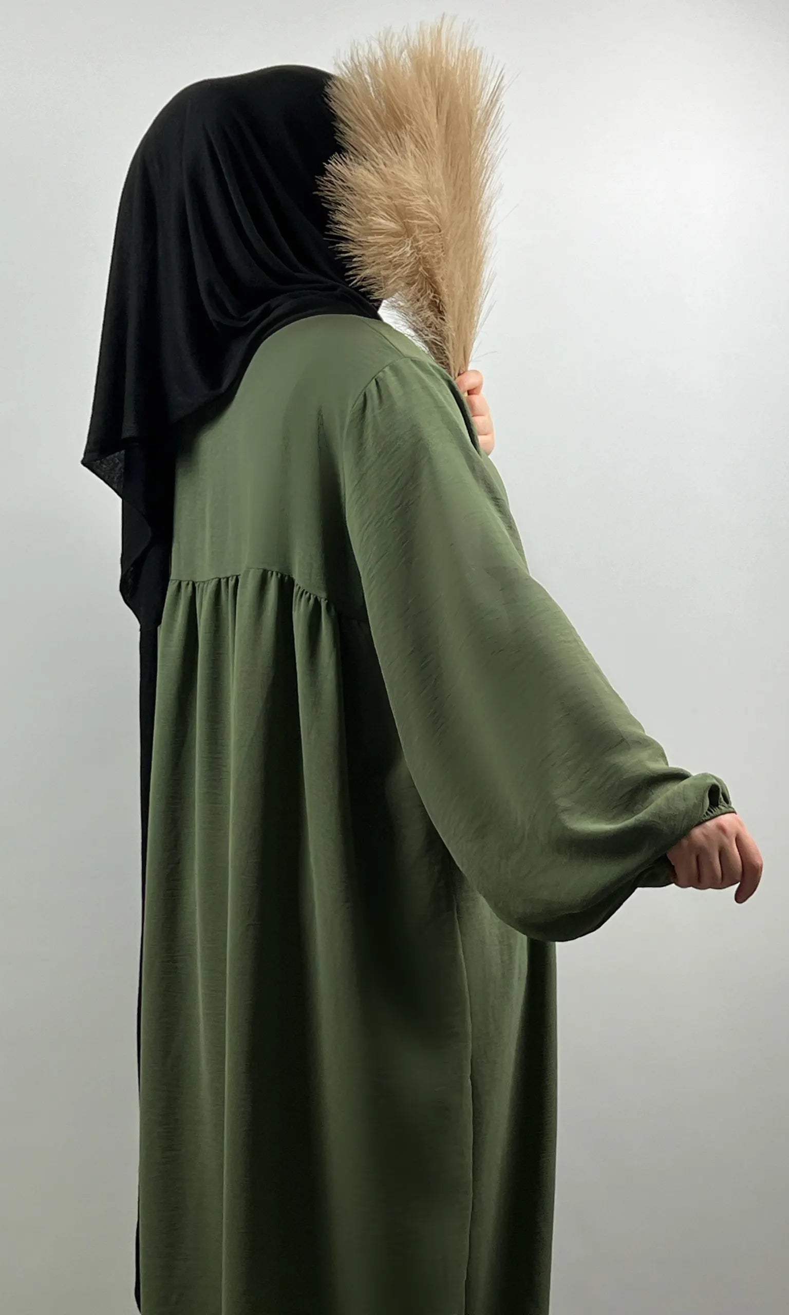 Olivgrüne Abaya aus Jazz-Stoff mit Ballonärmeln, seitliche Ansicht.