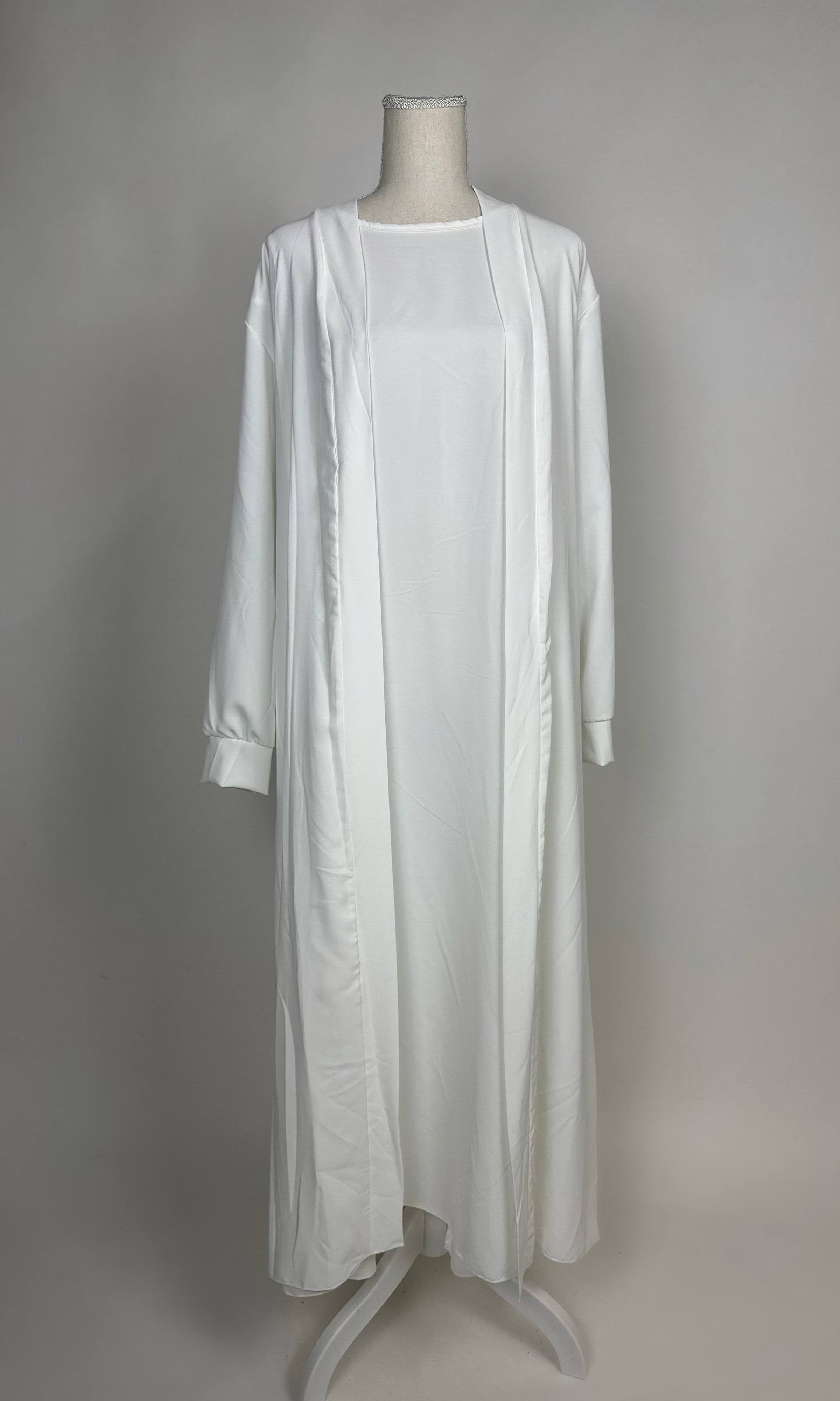 Weiße Open-Abaya Dubai aus Medina-Seide mit passendem Unterkleid ist in Vorderansicht zu sehen.