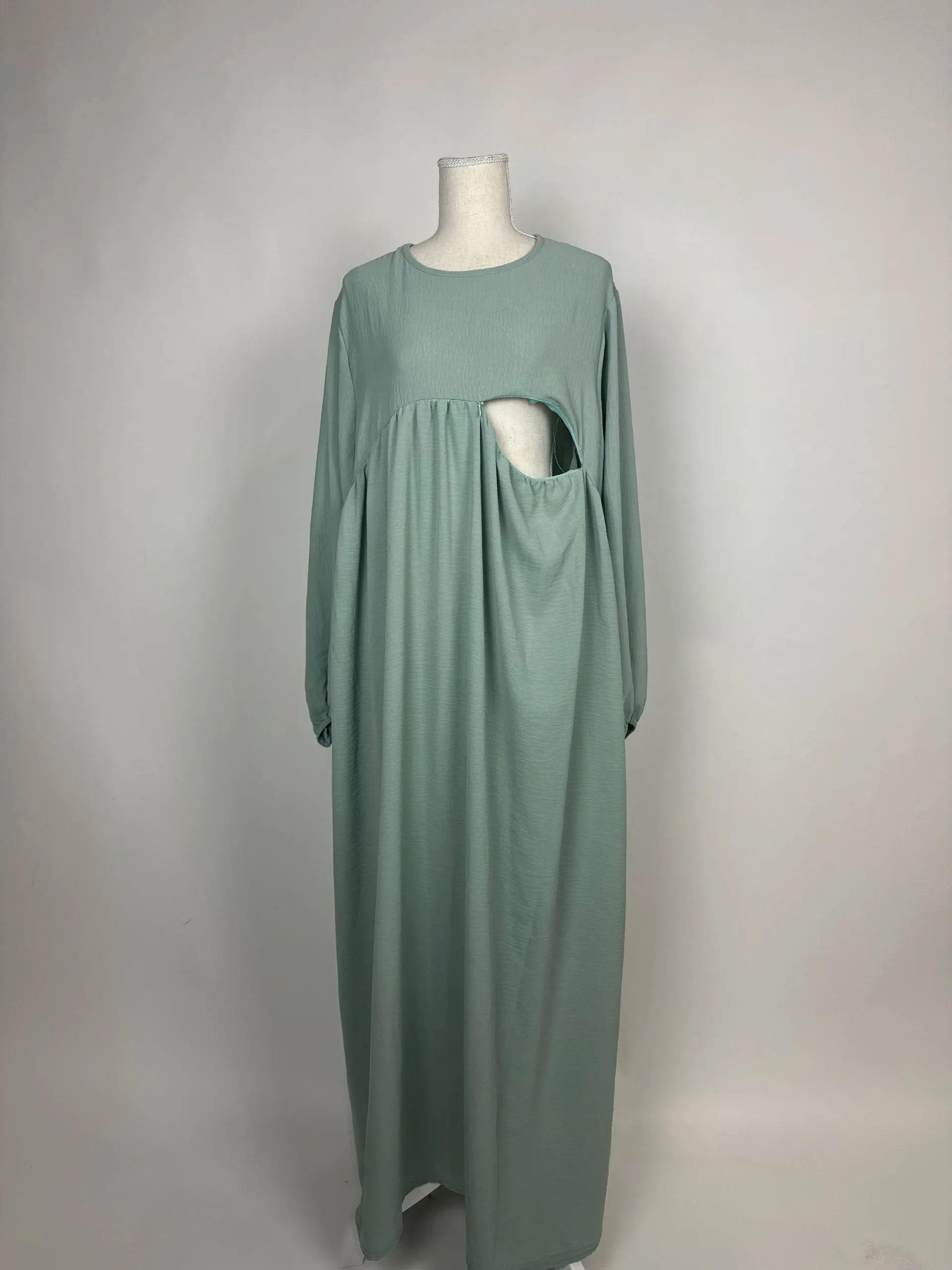 Mintgrüne Still-Abaya aus leichtem Crinkle-Stoff mit seitlicher Stillöffnung unter der Brust, Vorderansicht auf Puppe.