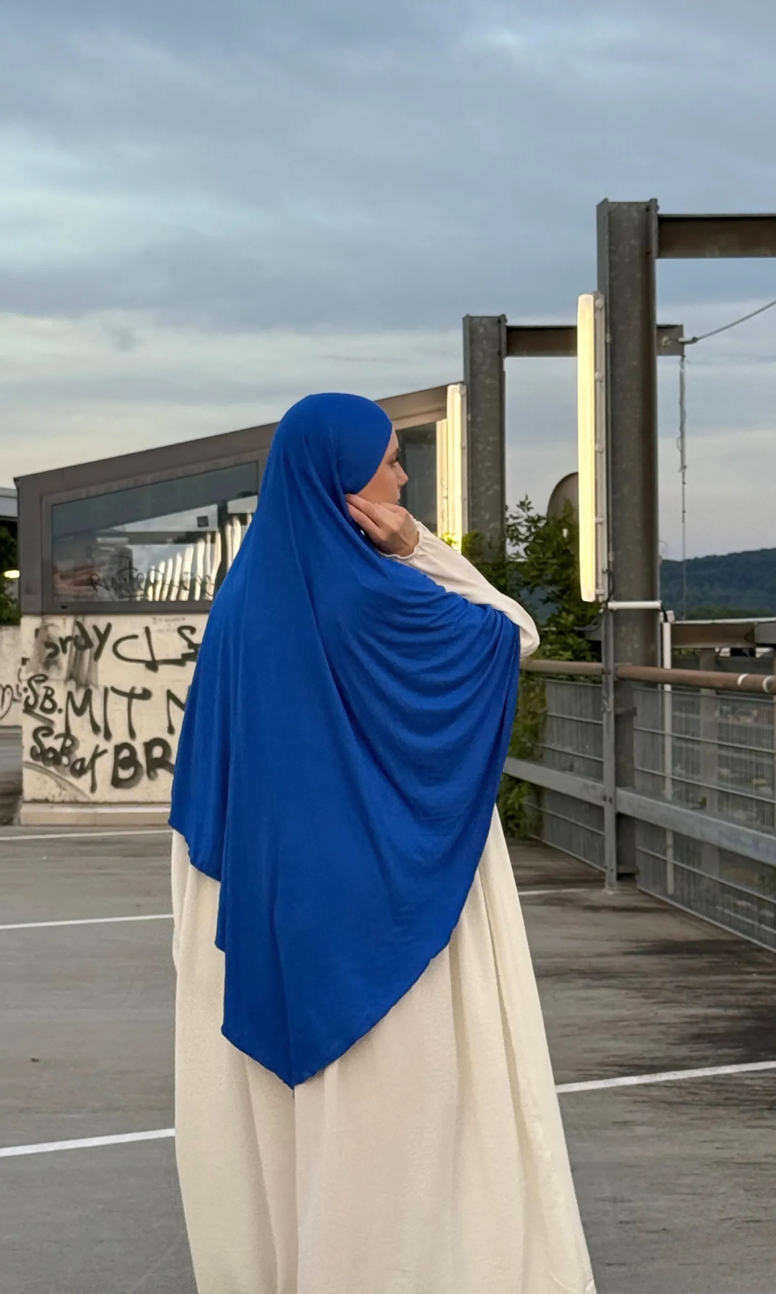 Jersey Khimar in royalblau aus Viskose-Elastan, seitlich-rückansicht an einer stehenden Person.