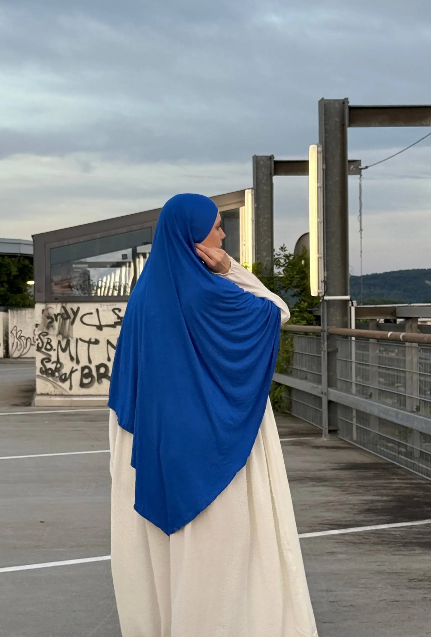 Jersey Khimar in royalblau aus Viskose-Elastan, seitlich-rückansicht an einer stehenden Person.