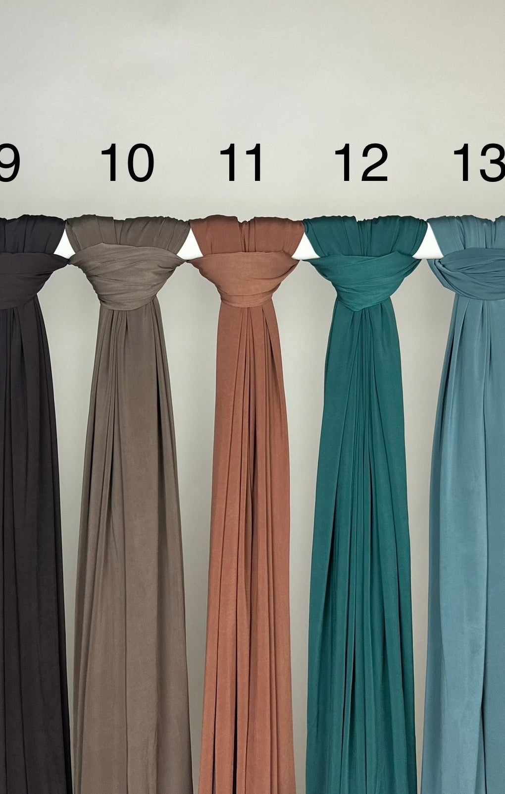 Mehrfarbiger Liquid Jersey Hijab, rutschfest und glänzend, Modest Abaya Style, Vorderansicht am Ständer hängend