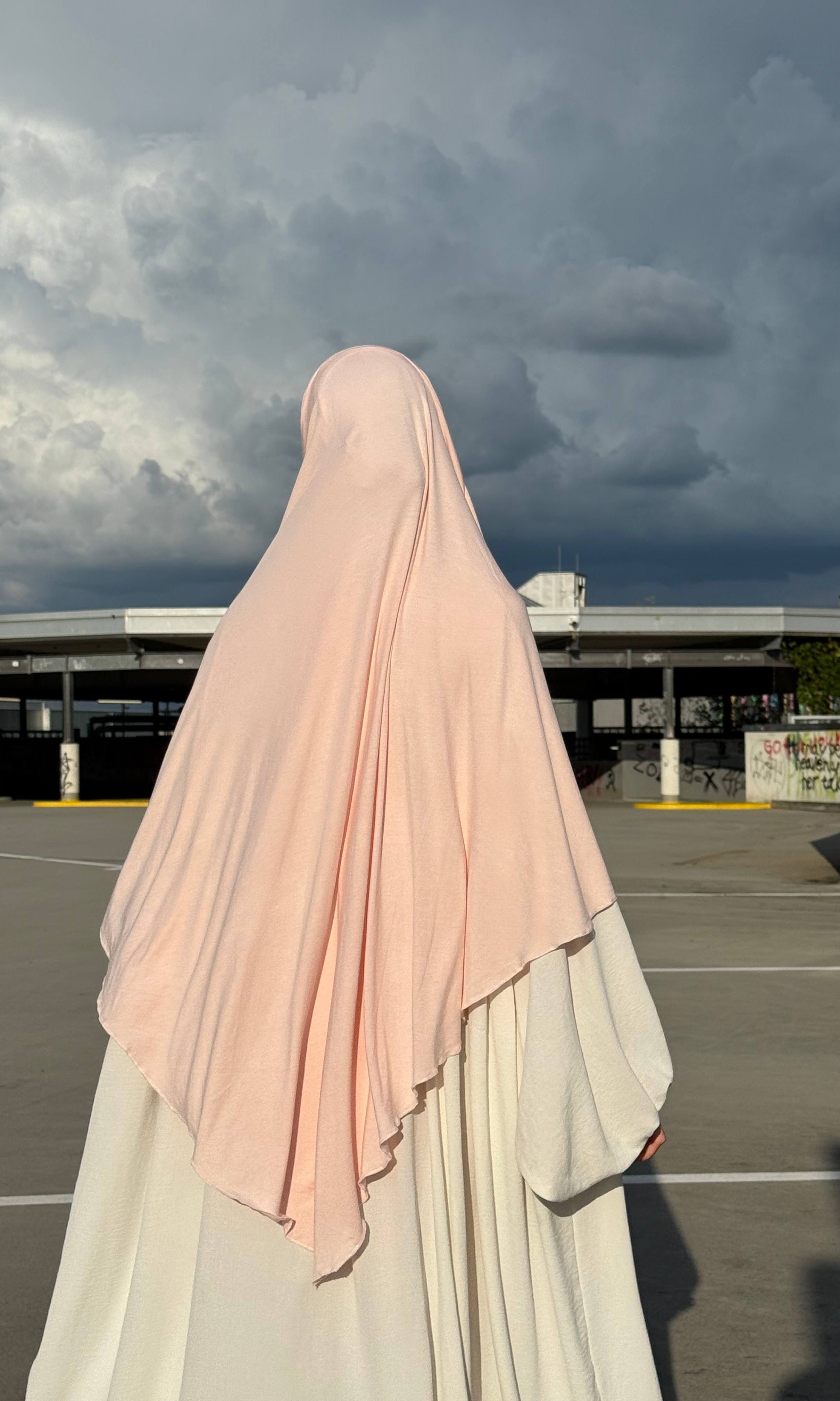 Jersey Khimar in hellrosa aus Viskose-Elastan, Rückenansicht mit länger fallendem Rückenteil.