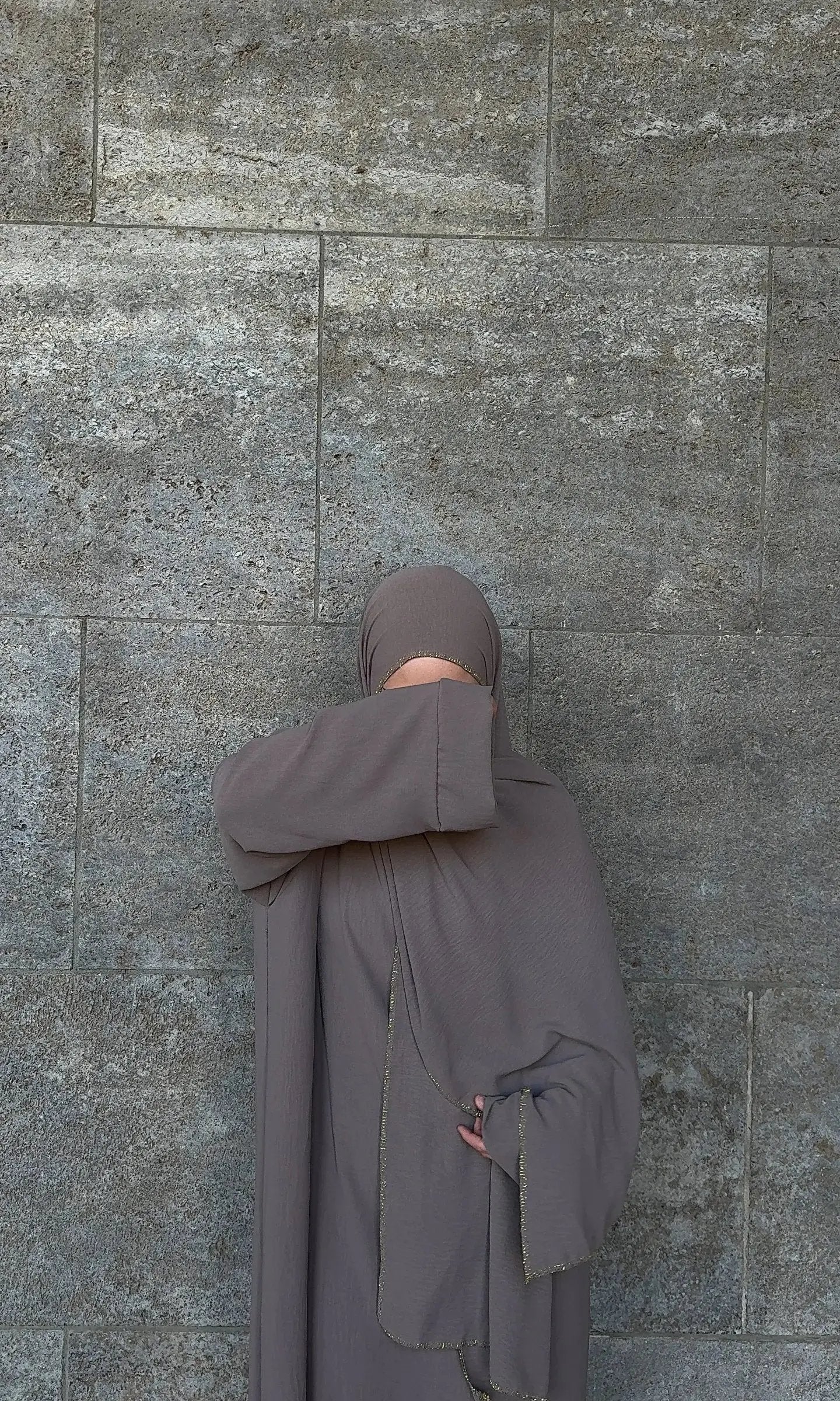 Taupefarbene Einteiler-Abaya aus fließendem Stoff mit integriertem Hijab und goldener Kante, Vorderansicht