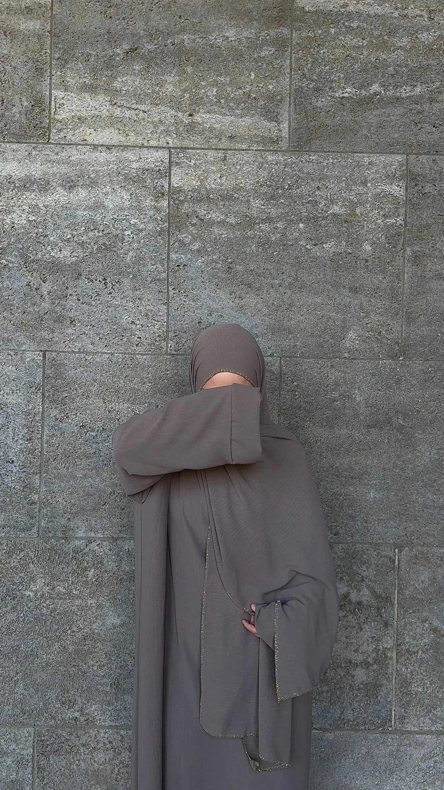 Taupefarbene Einteiler-Abaya aus fließendem Stoff mit integriertem Hijab und goldener Kante, Vorderansicht