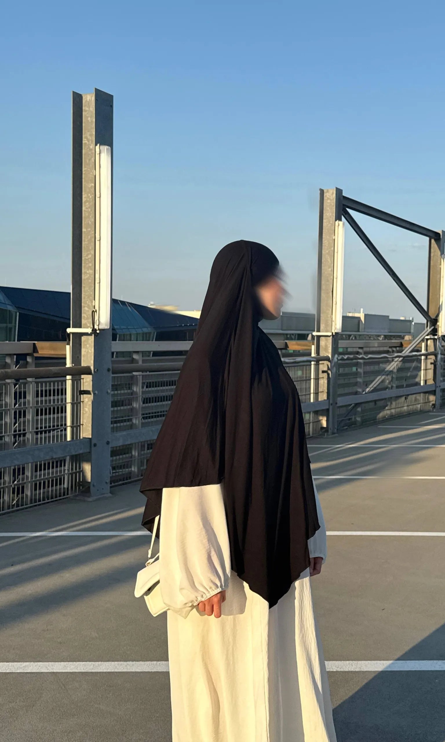 Jersey Khimar in Schwarz aus Jersey (95% Viskose, 5% Elastan), seitliche Ansicht an einer stehenden Person.