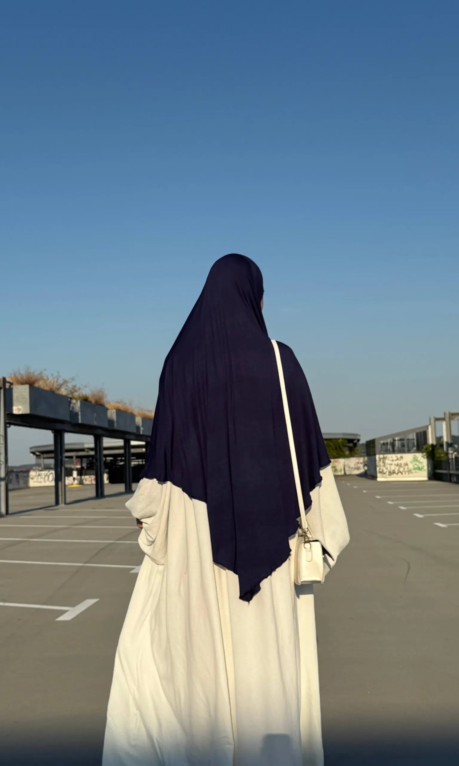 Jersey Khimar in Dunkelblau aus Viskose-Elastan, Rückenansicht einer stehenden Person.